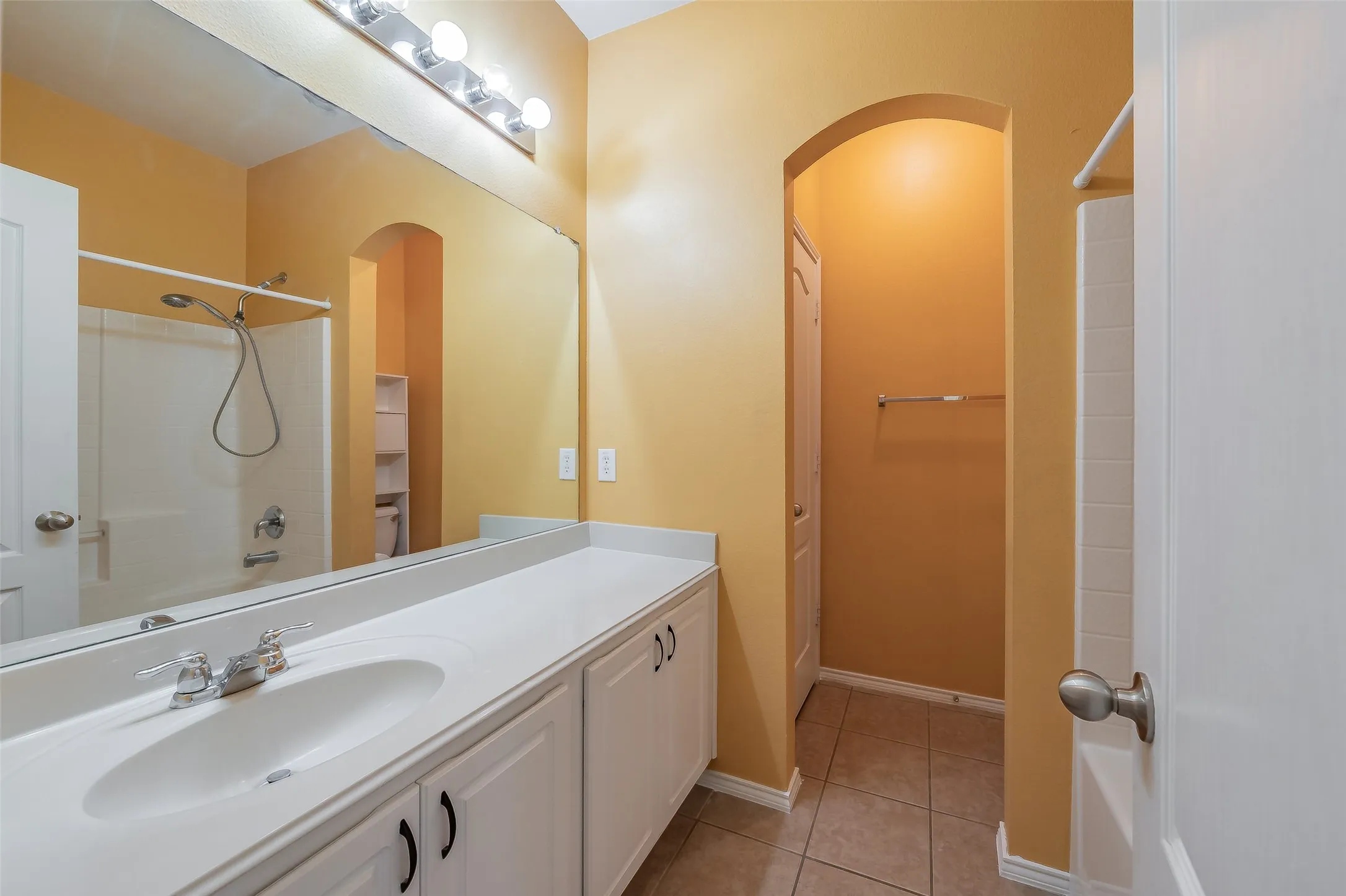 Bathroom vanity with an integrated sink, polished chrome faucet, and white cabinetry