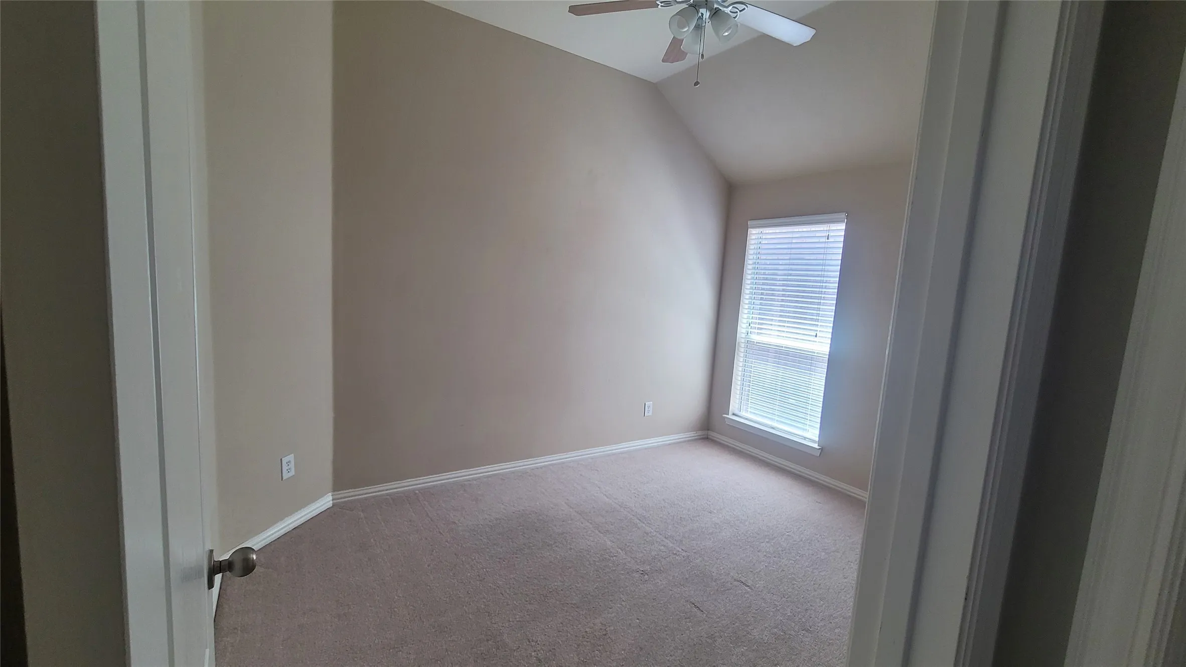 Vaulted ceiling, ceiling fan, carpet flooring, window with blinds, and neutral wall tones