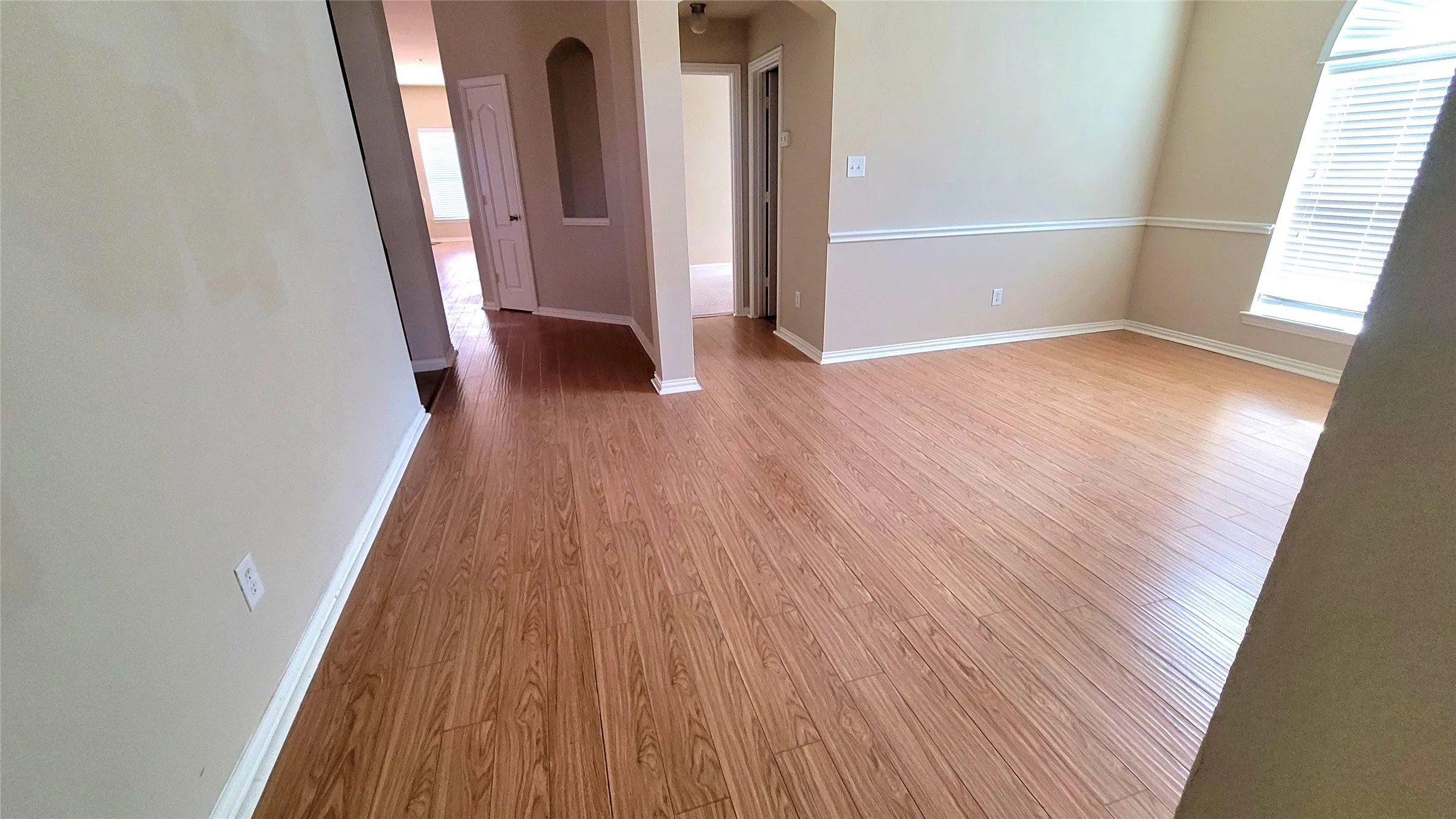 Wood-finish flooring throughout, neutral painted walls, and white trim work