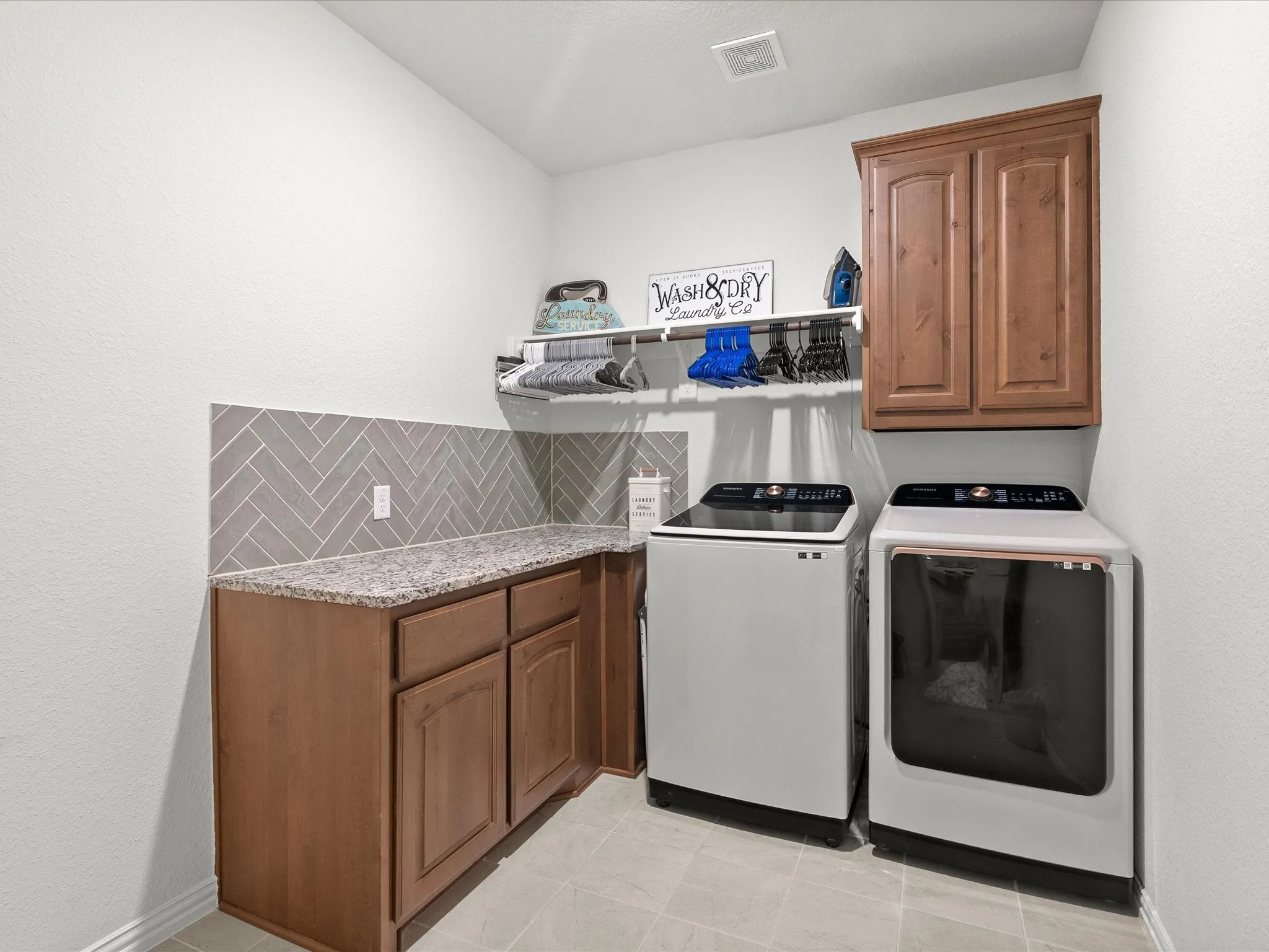 laundry room with built-in cabinetry, shelf & rod, space for fridge/freezer