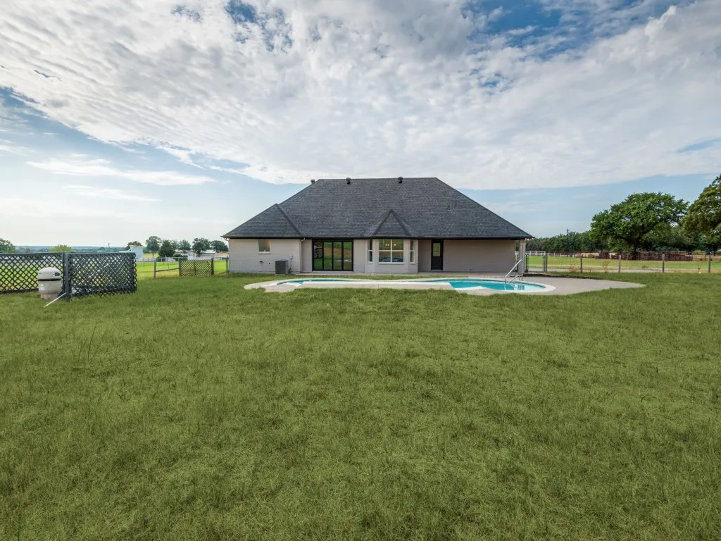Expansive backyard with a swimming pool and concrete patio