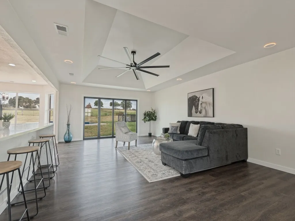 Vaulted ceiling with a contemporary ceiling fan, recessed lighting, wood-finish flooring, and sliding glass doors