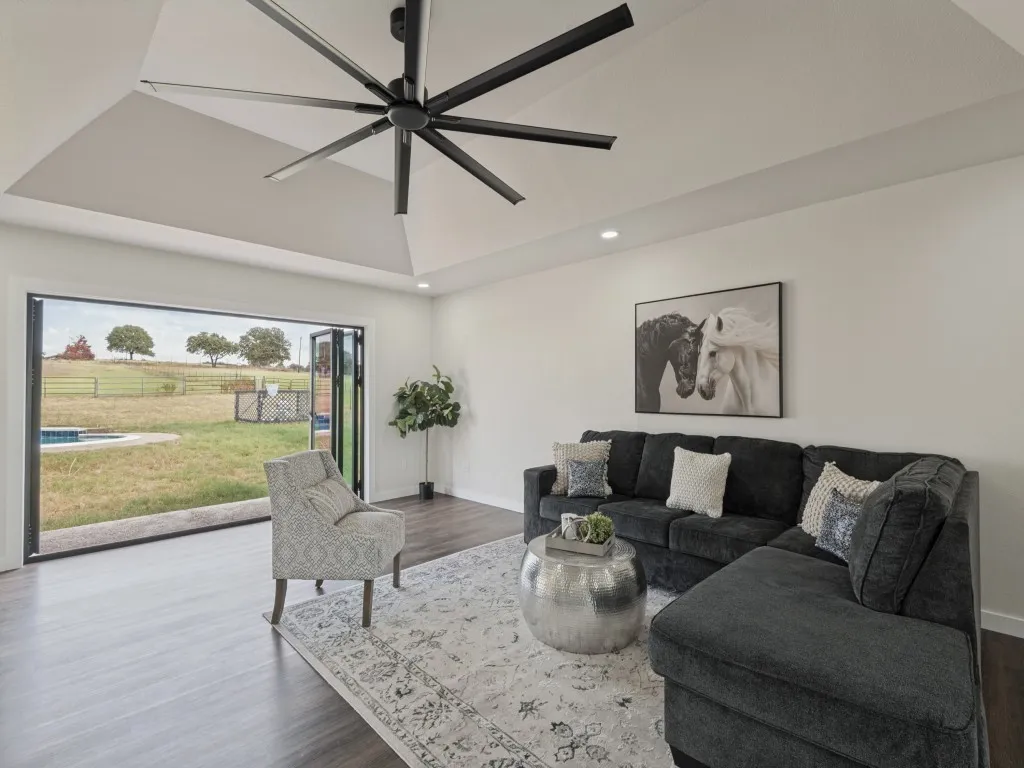 Recessed lighting and a multi-blade ceiling fan complement the tray ceiling