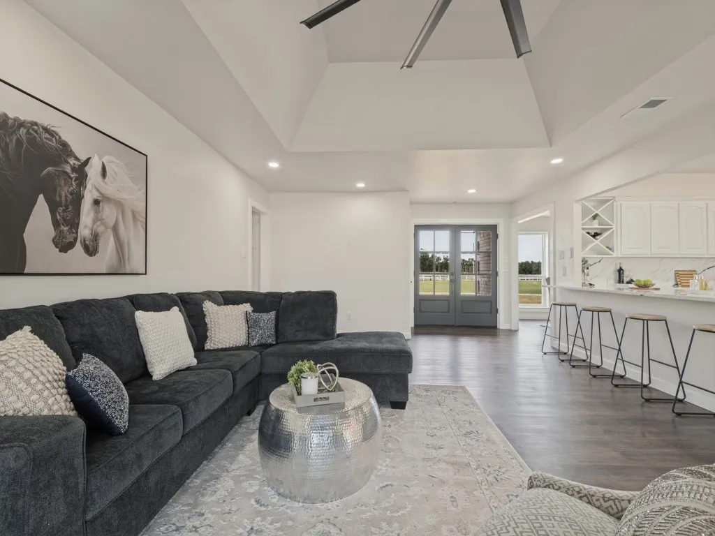 Vaulted ceiling with recessed lighting, dark wood-finish flooring, white cabinetry, integrated wine rack, and a double entry door with glass panels