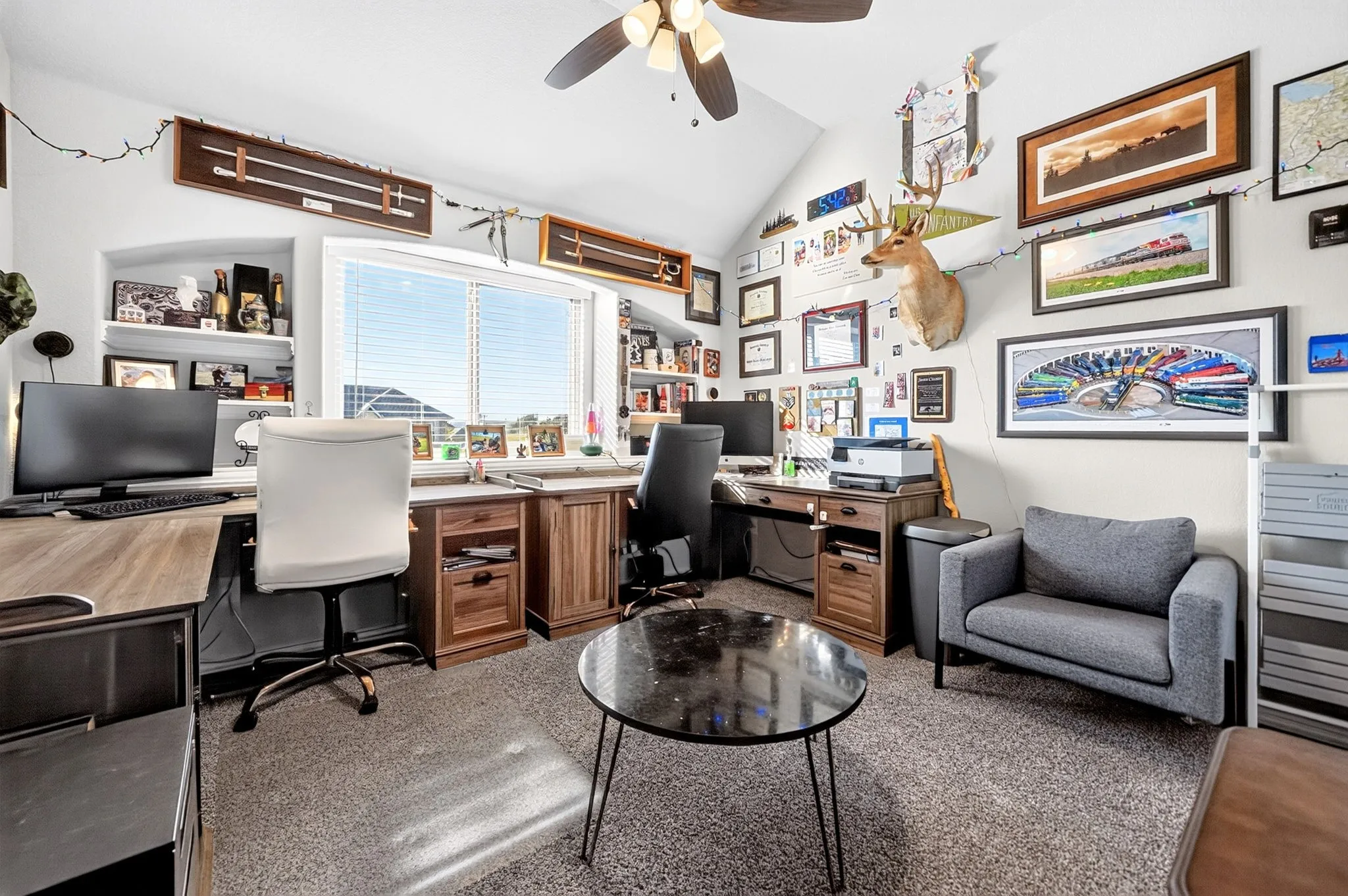 Vaulted ceiling with a ceiling fan, built-in shelving, large window with horizontal blinds, and carpeting