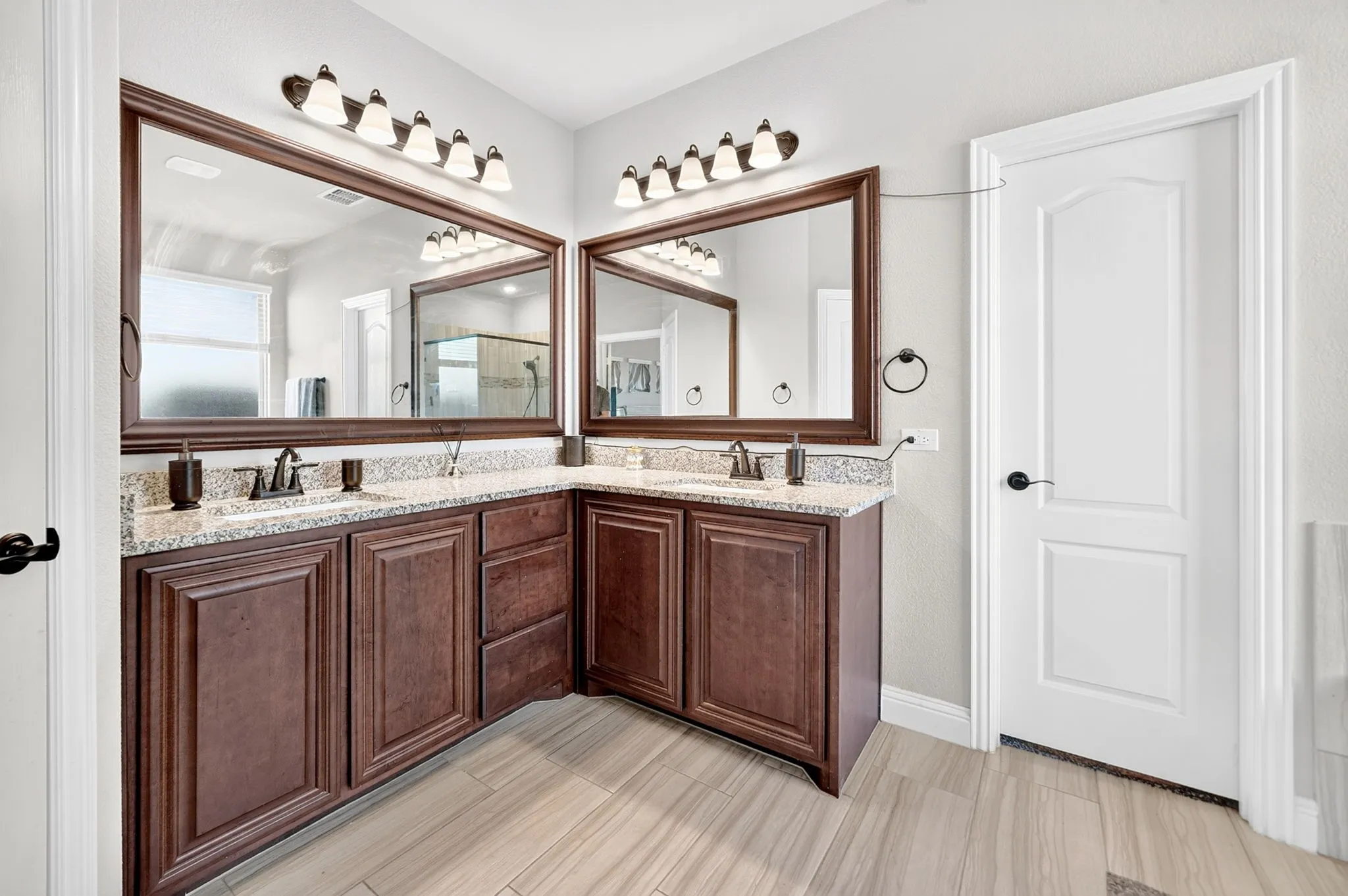 Dual vanity with wood-finish cabinetry and light-toned countertops