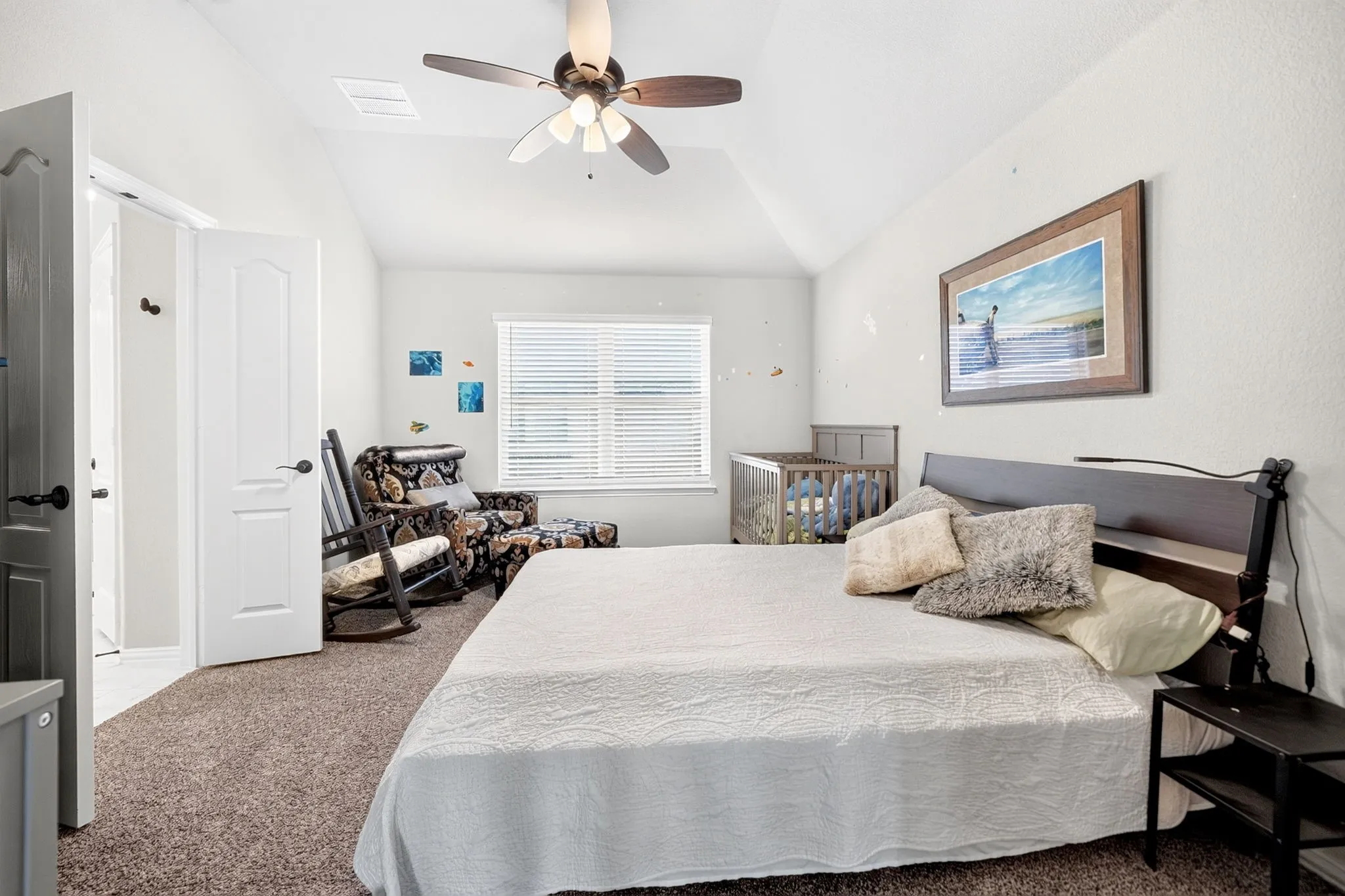 Vaulted ceiling with a ceiling fan, carpet flooring, window with blinds, and white panel doors