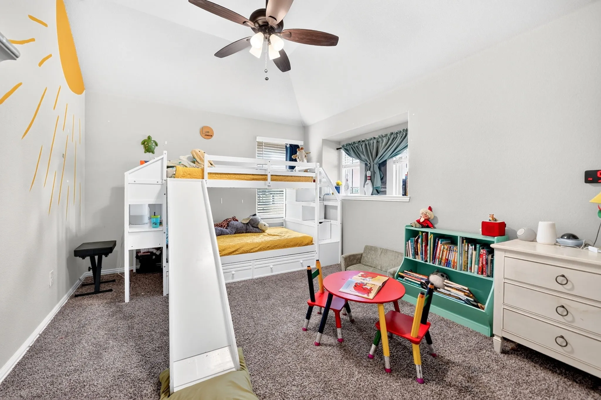 Vaulted ceiling with a ceiling fan, carpeted flooring, and a built-in window