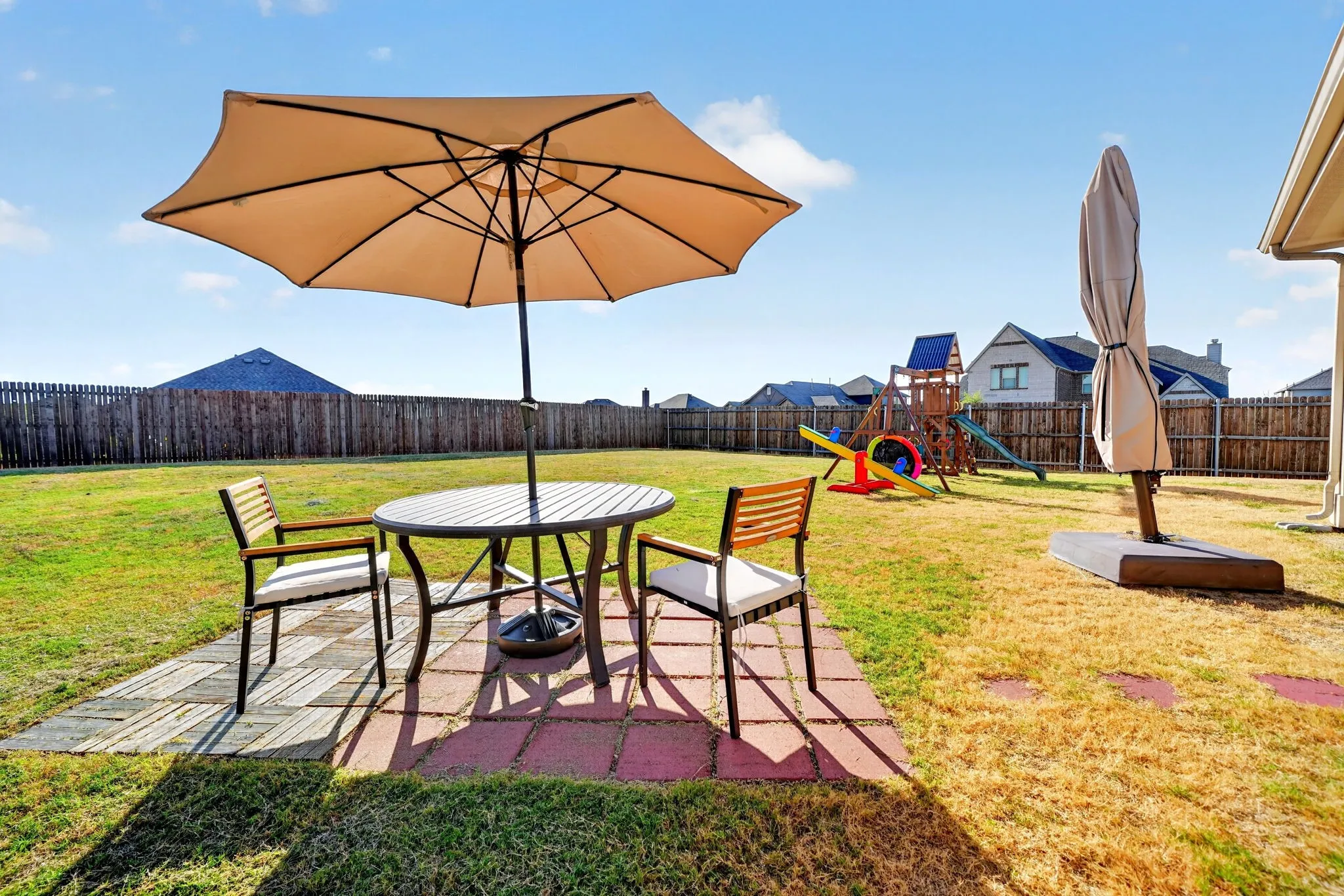 Expansive backyard featuring a full perimeter privacy fence and a paved patio area