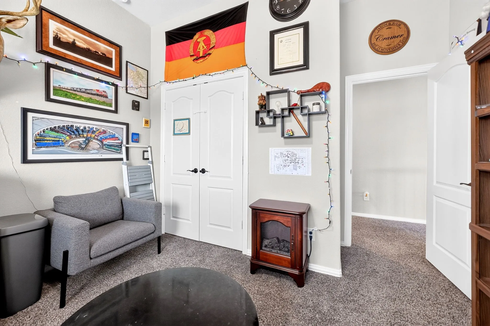 Carpeted room with double closet doors, a built-in bookshelf, and a doorway