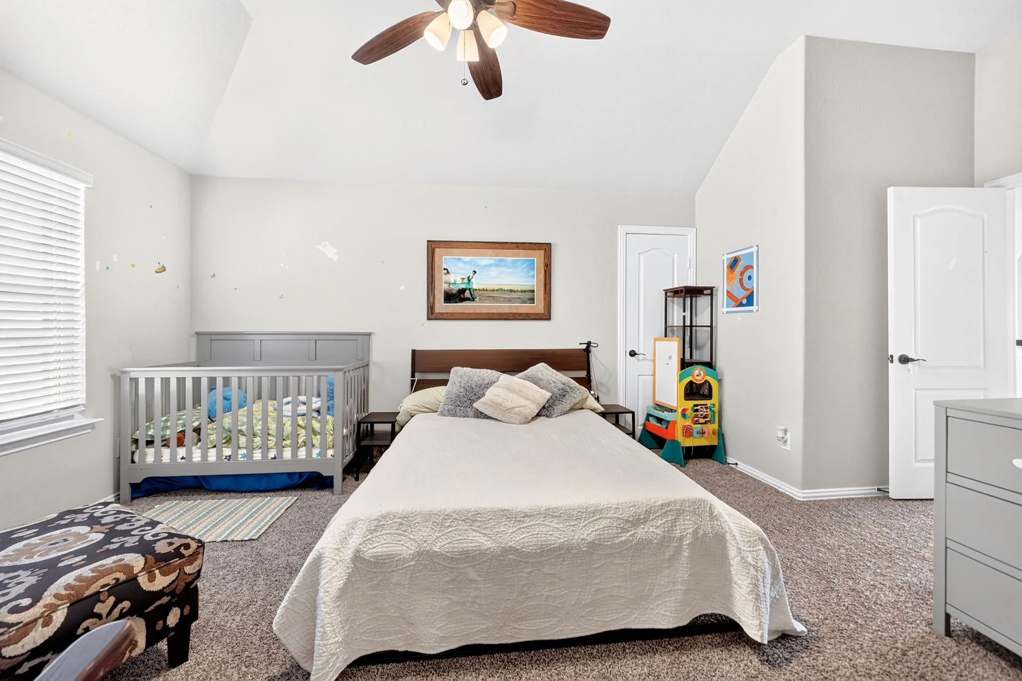 Vaulted ceiling with a ceiling fan, neutral wall paint, and white trim