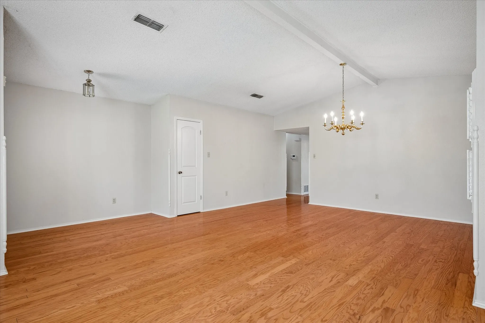Enter into the gracious open living and dining room with vaulted ceiling and gleaming wood floors.