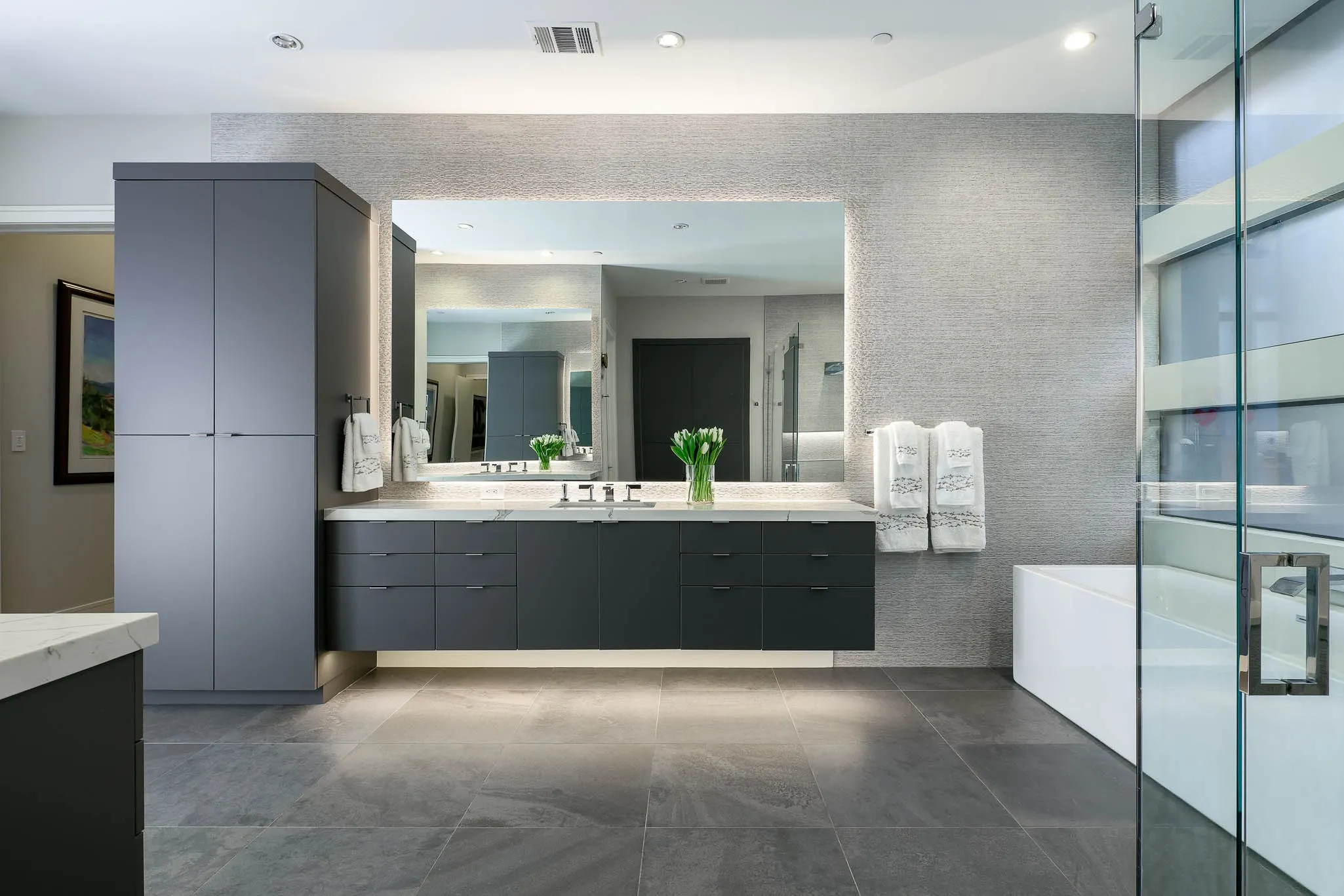 Primary bathroom with large vanities, stand alone tub and shower and secondary washer/dryer hookup