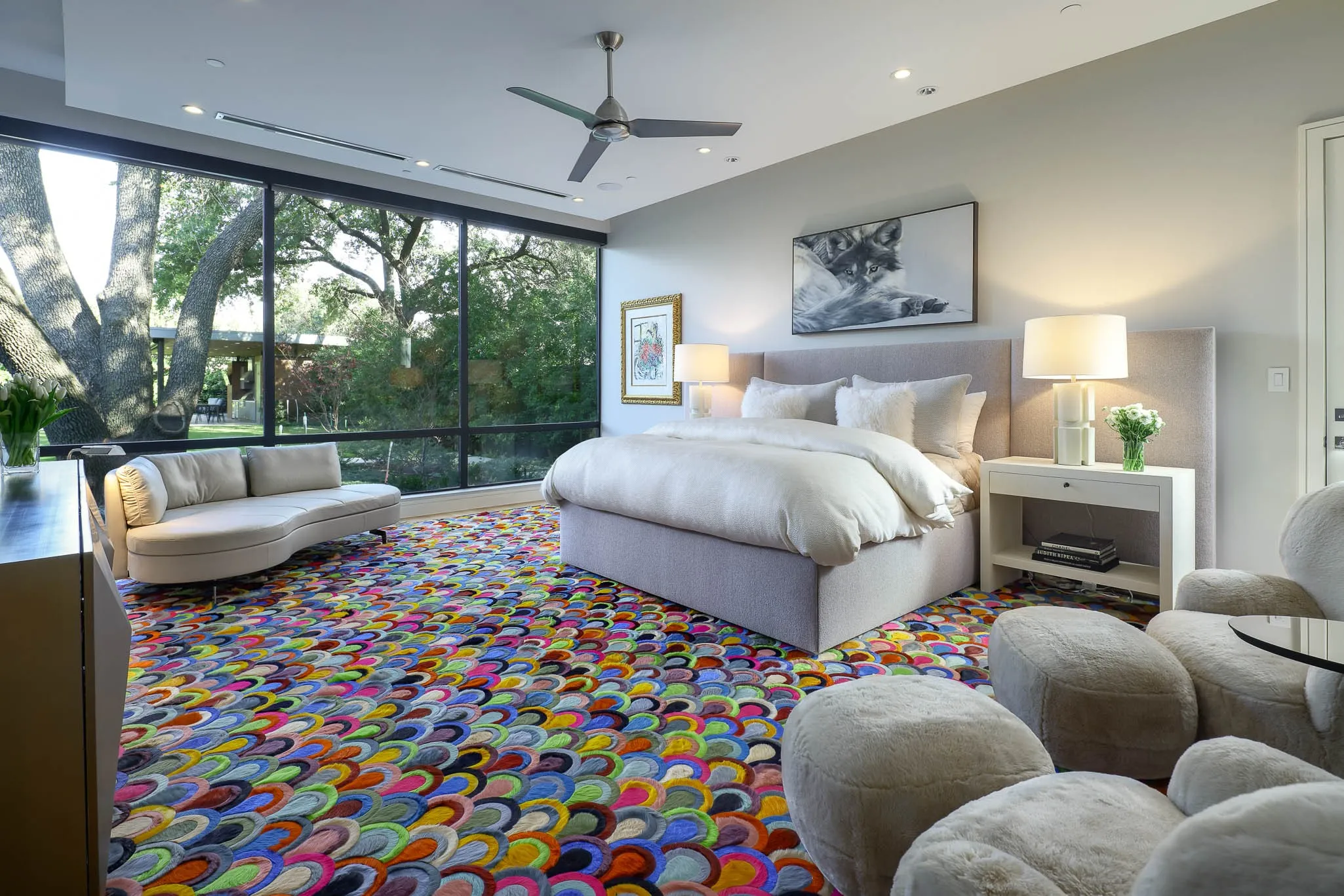 Primary bedroom with sitting area overlooking landscaped backyard and private door to dog run