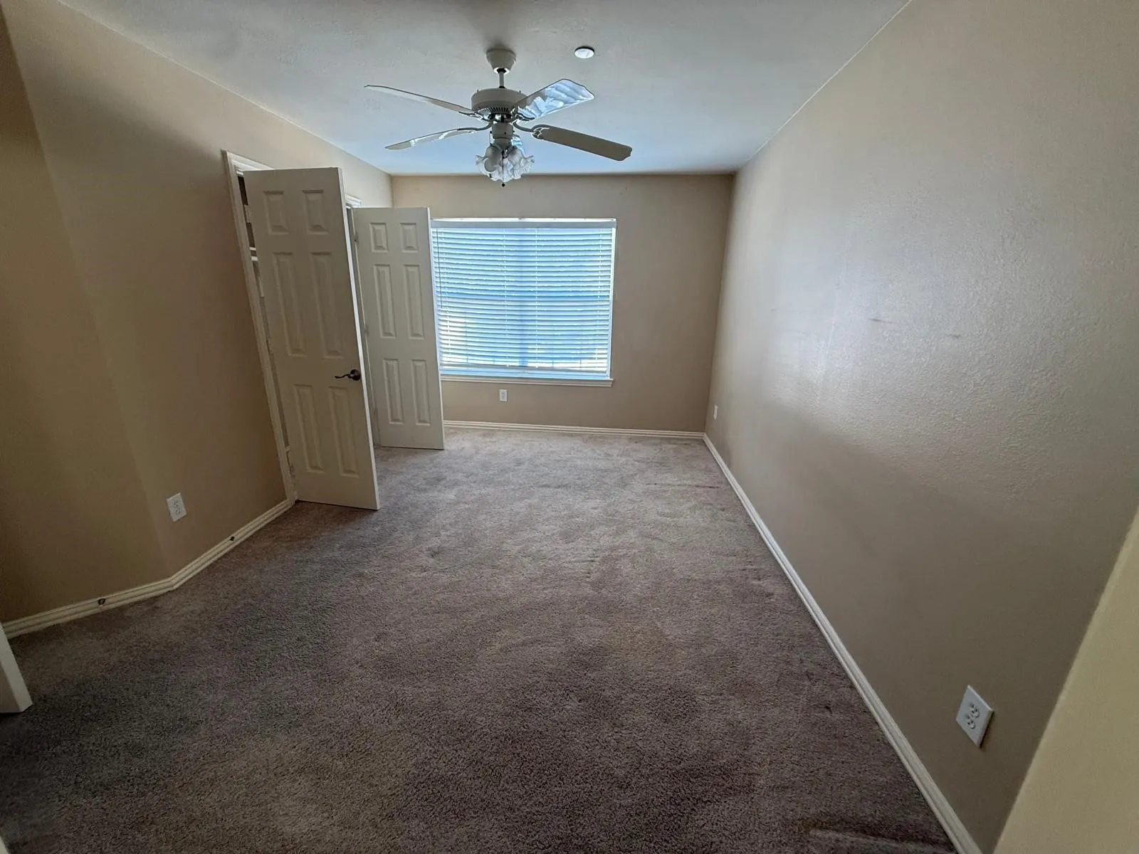 Recessed window with blinds, ceiling fan with light fixture, and textured walls