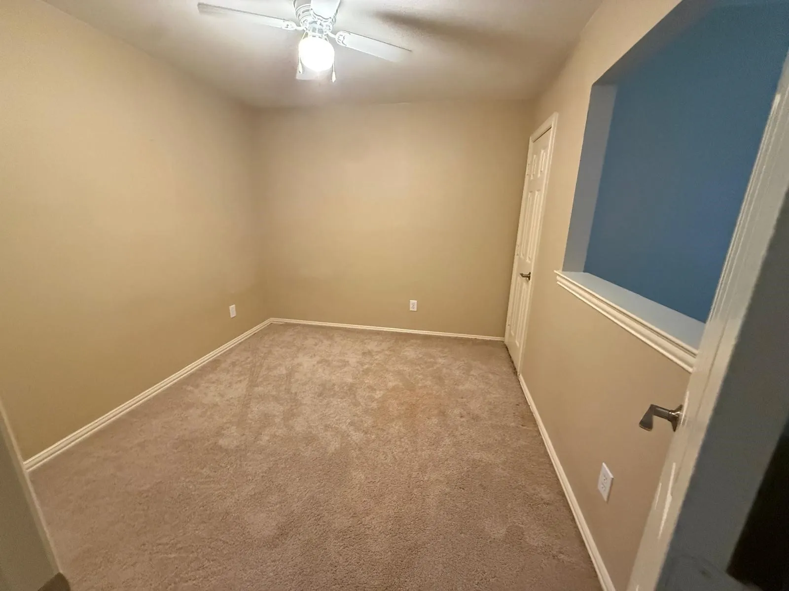 Neutral-toned walls complement plush carpeting