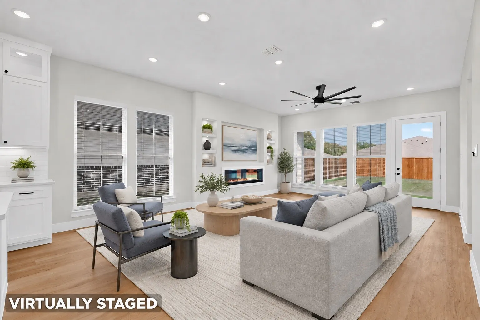 Recessed lighting throughout, wood-finish flooring, white shaker cabinetry with black hardware, built-in electric fireplace, and a ceiling fan