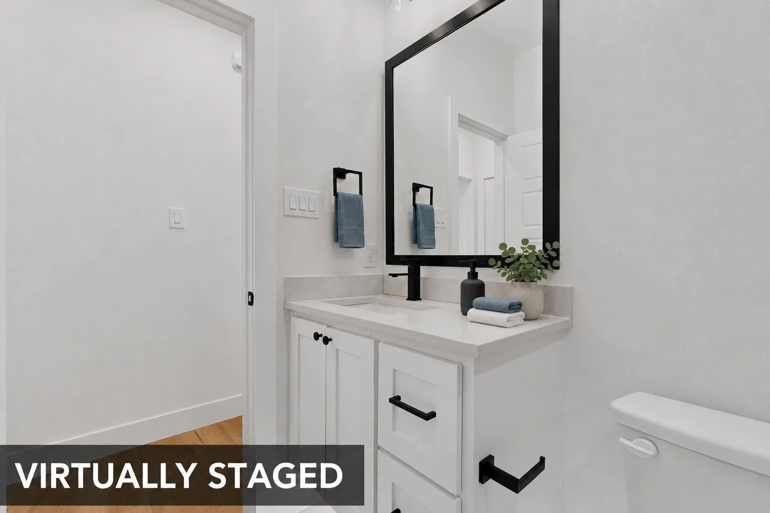 White vanity with shaker-style cabinetry, a light-toned countertop, and a rectangular undermount sink