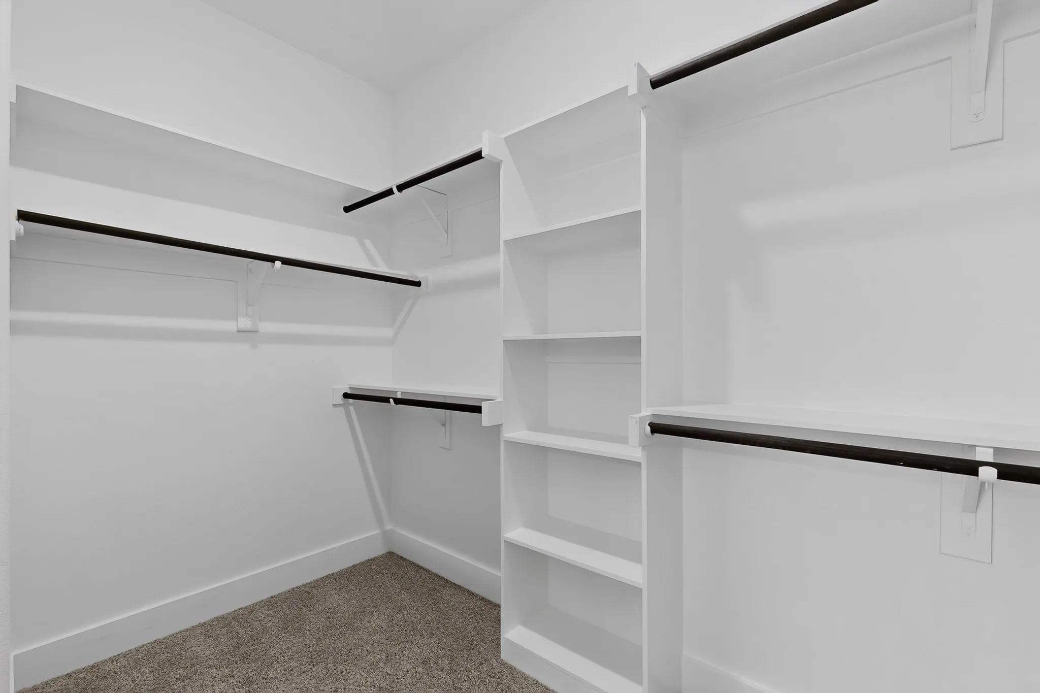 Integrated white shelving, multiple hanging rods, built-in storage, and wall-mounted shelving units