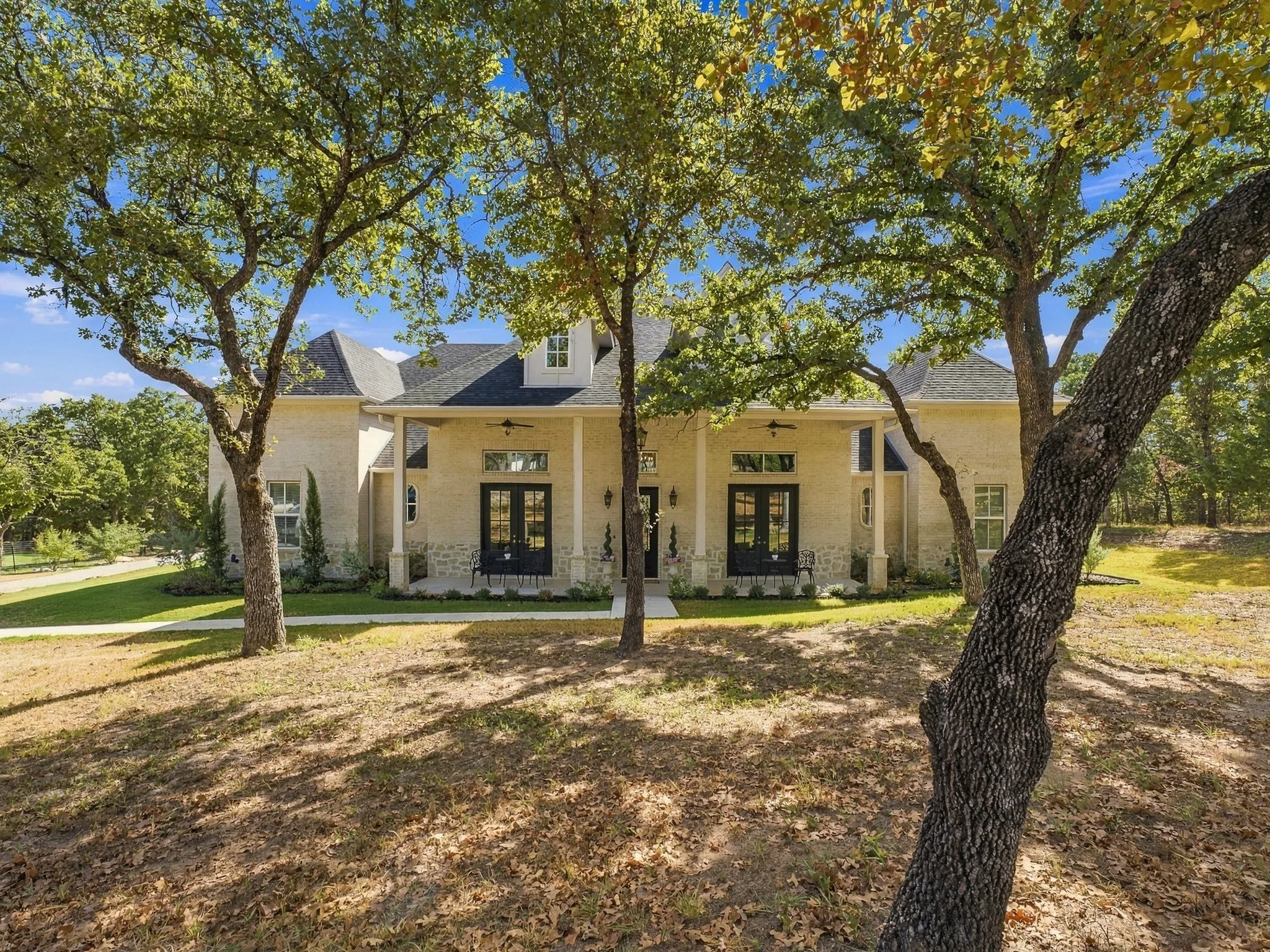 A beautiful French Traditional style home surrounded by mature trees in a peaceful, private setting.