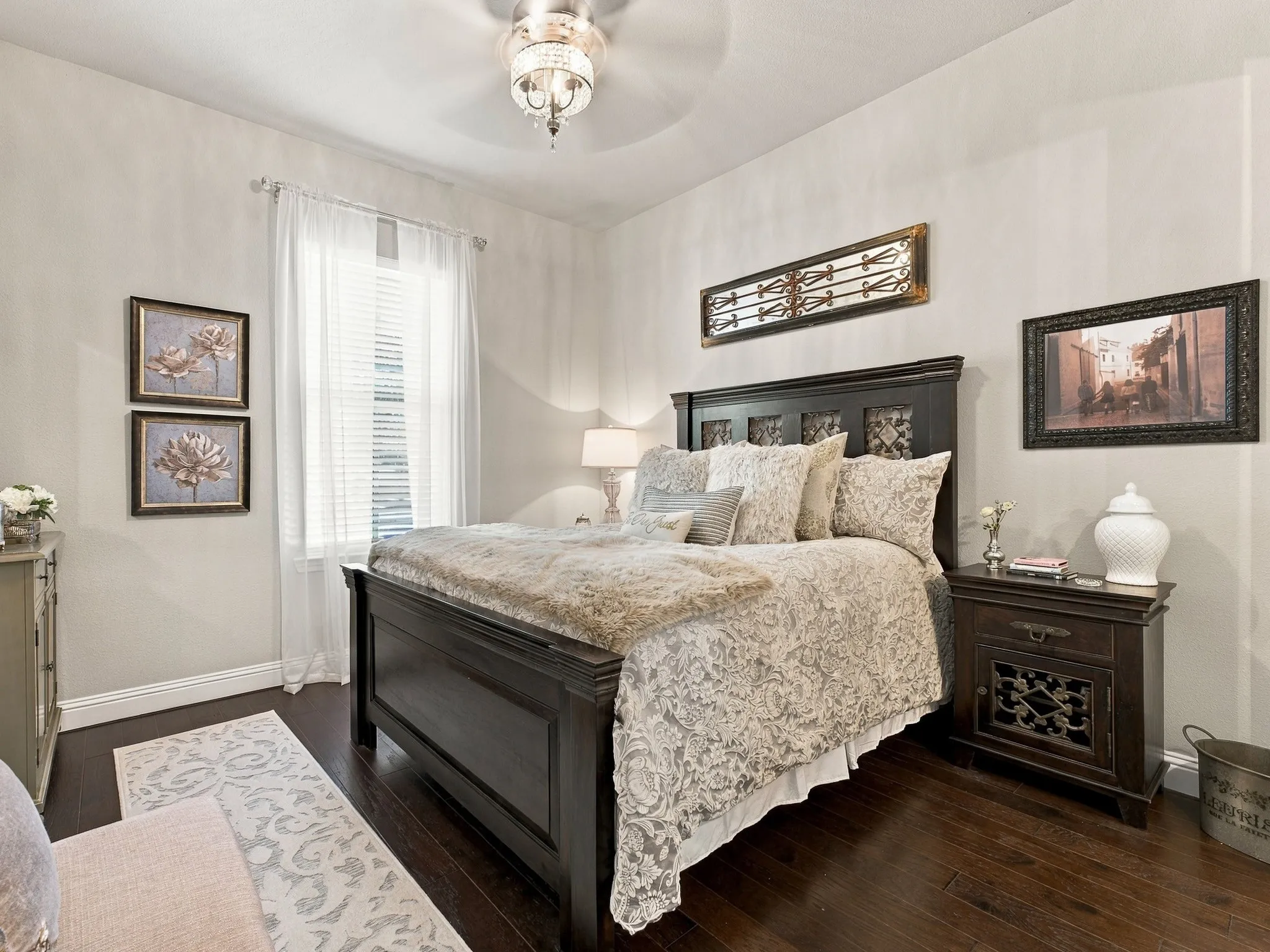 Rich wood-finish flooring, built-in overhead lighting, light-filtering window treatments, and a decorative ceiling fan