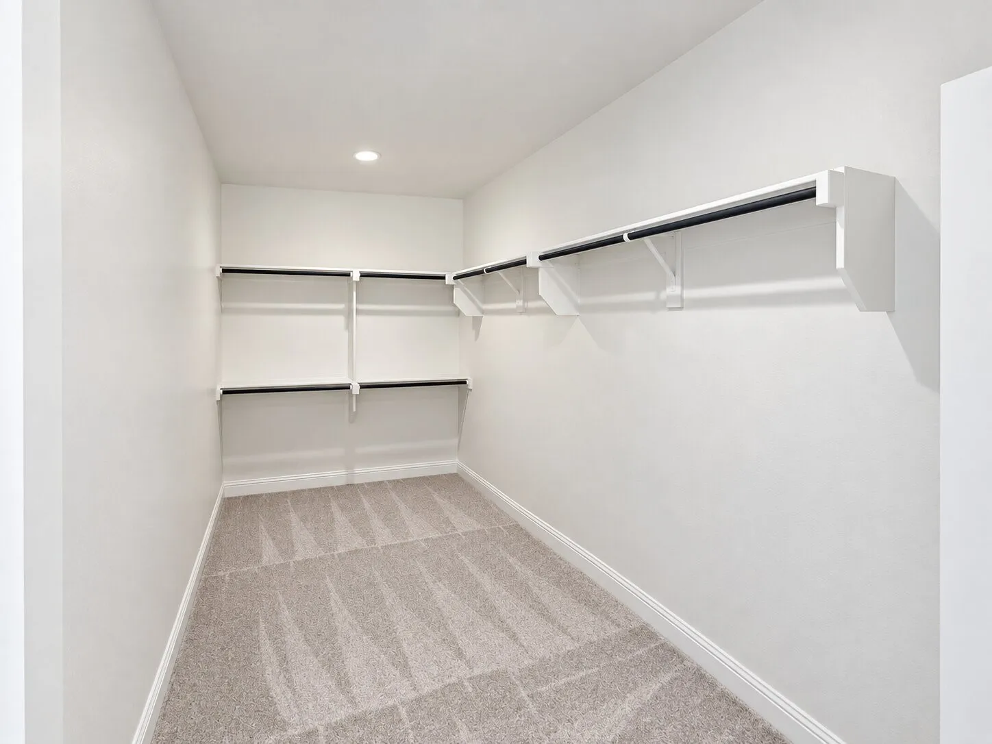 Recessed lighting, wall-mounted shelving, and carpeted flooring