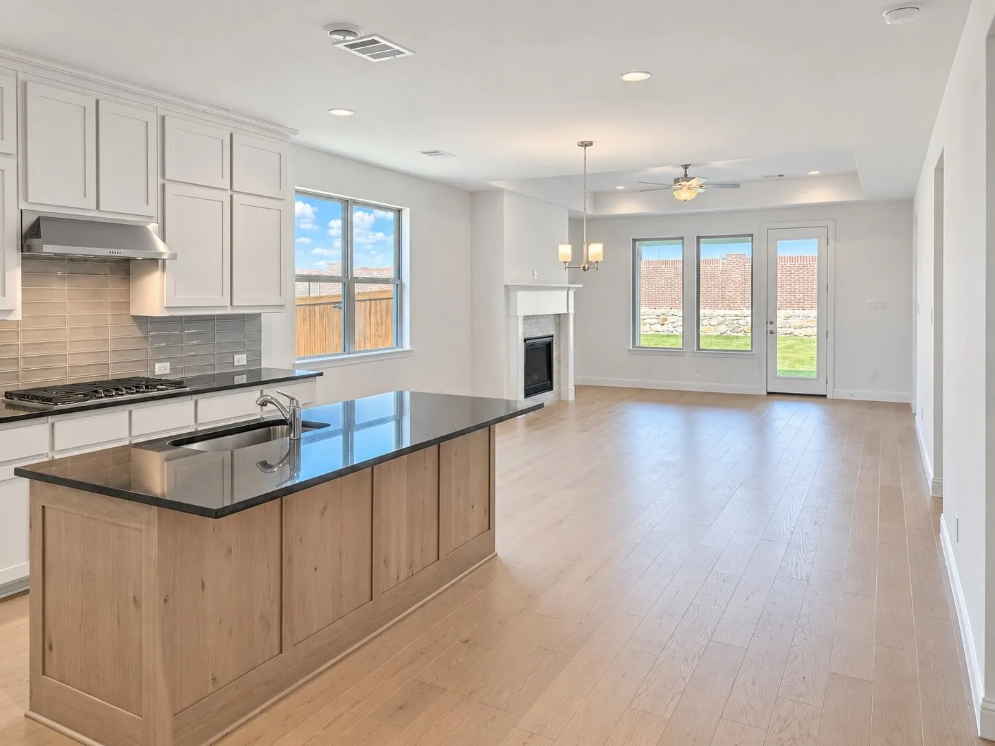Kitchen island with a built-in sink, wood-finish paneling, and a dark countertop