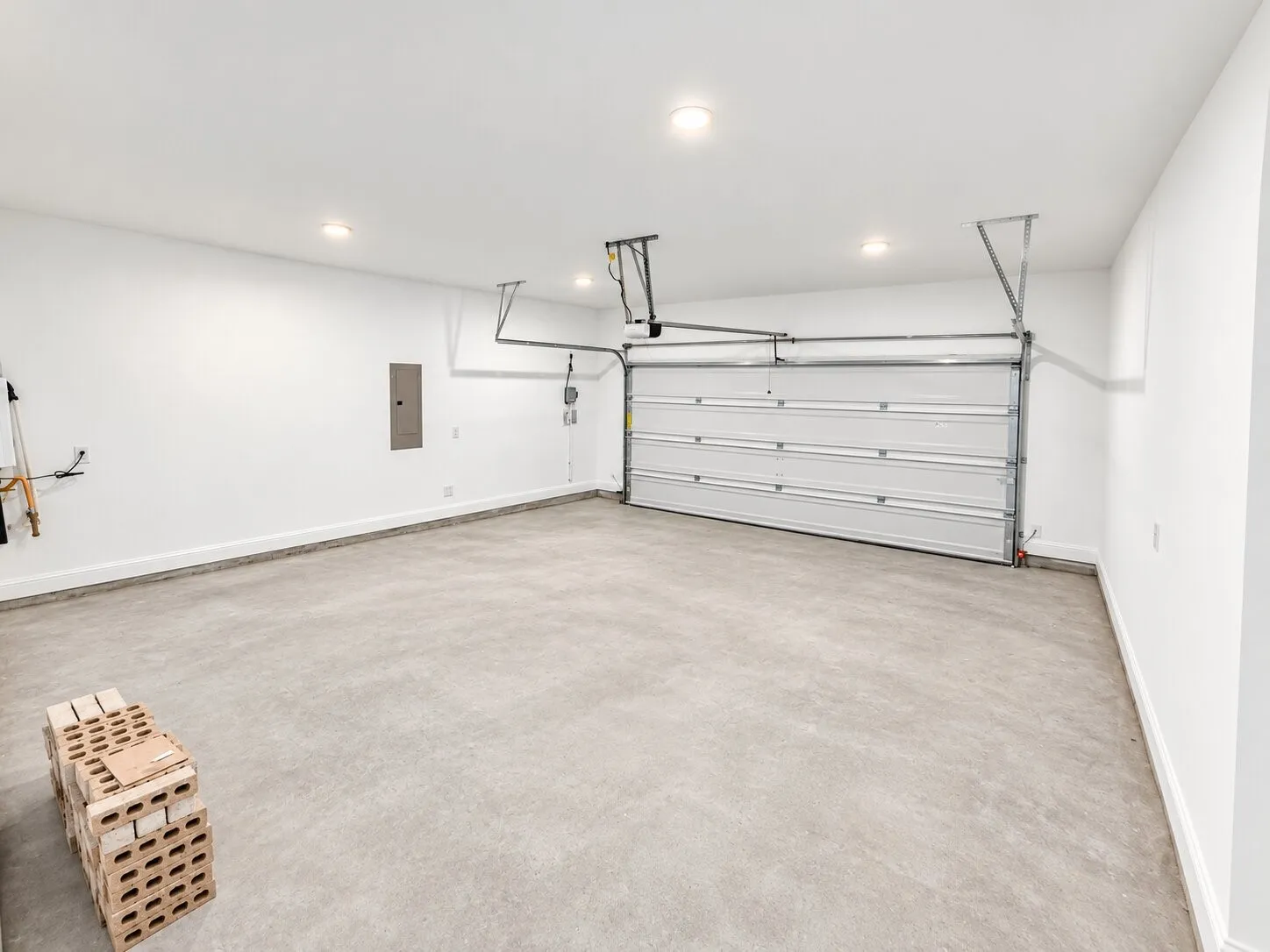 Spacious garage with a concrete floor, white walls, and recessed lighting