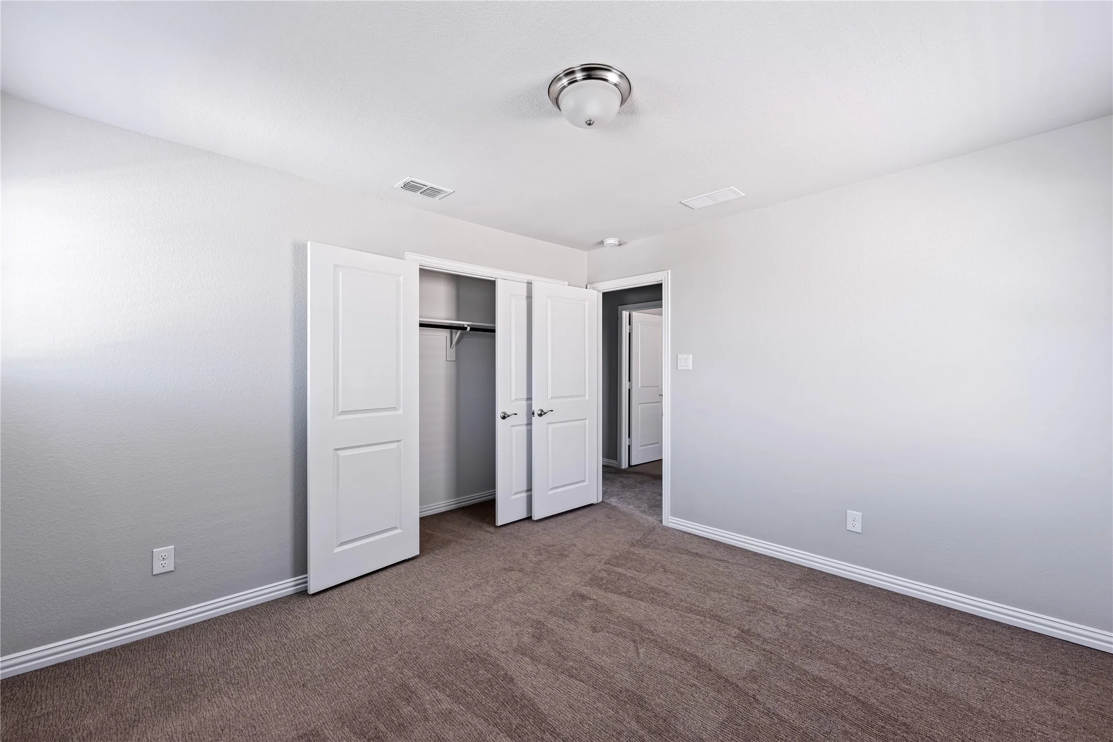 Neutral wall paint, plush carpet flooring, white trim, and a flush mount ceiling light
