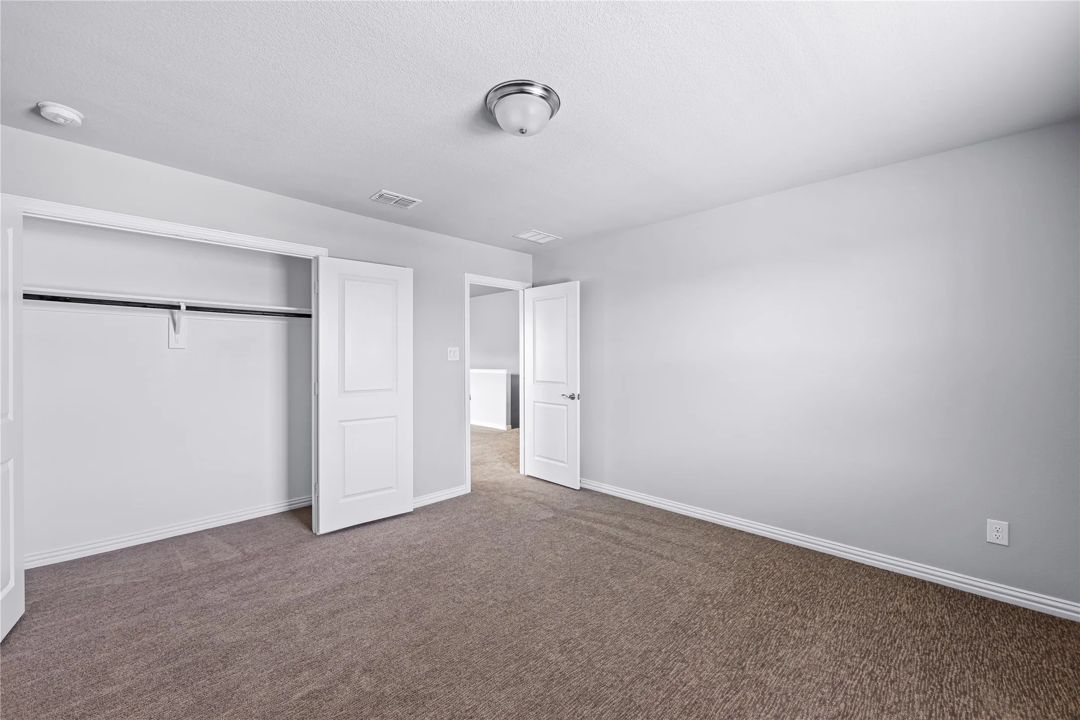 Neutral gray walls with white trim, brown carpeting, recessed lighting, and a flush mount ceiling fixture