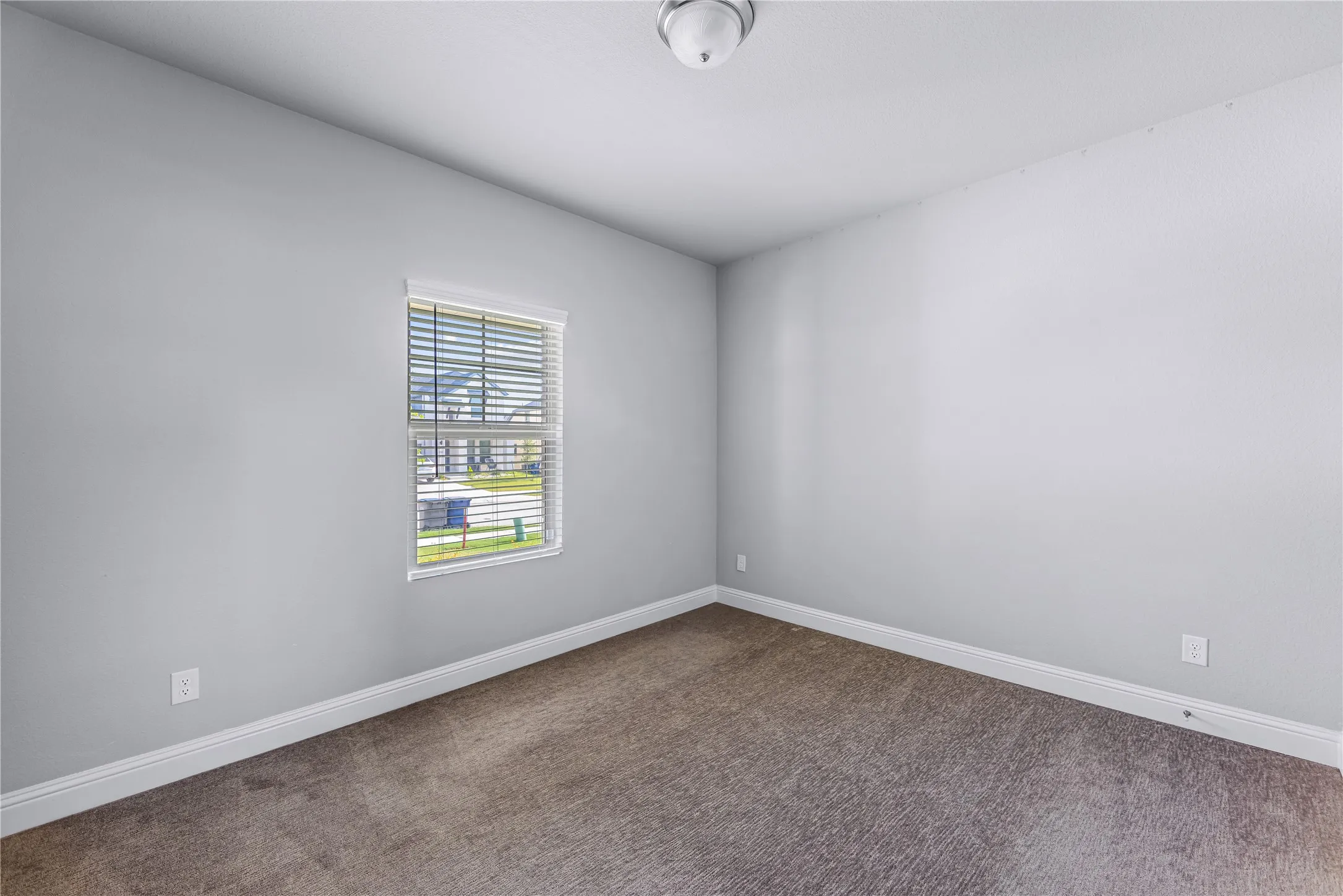 Neutral wall finishes with a window featuring horizontal blinds