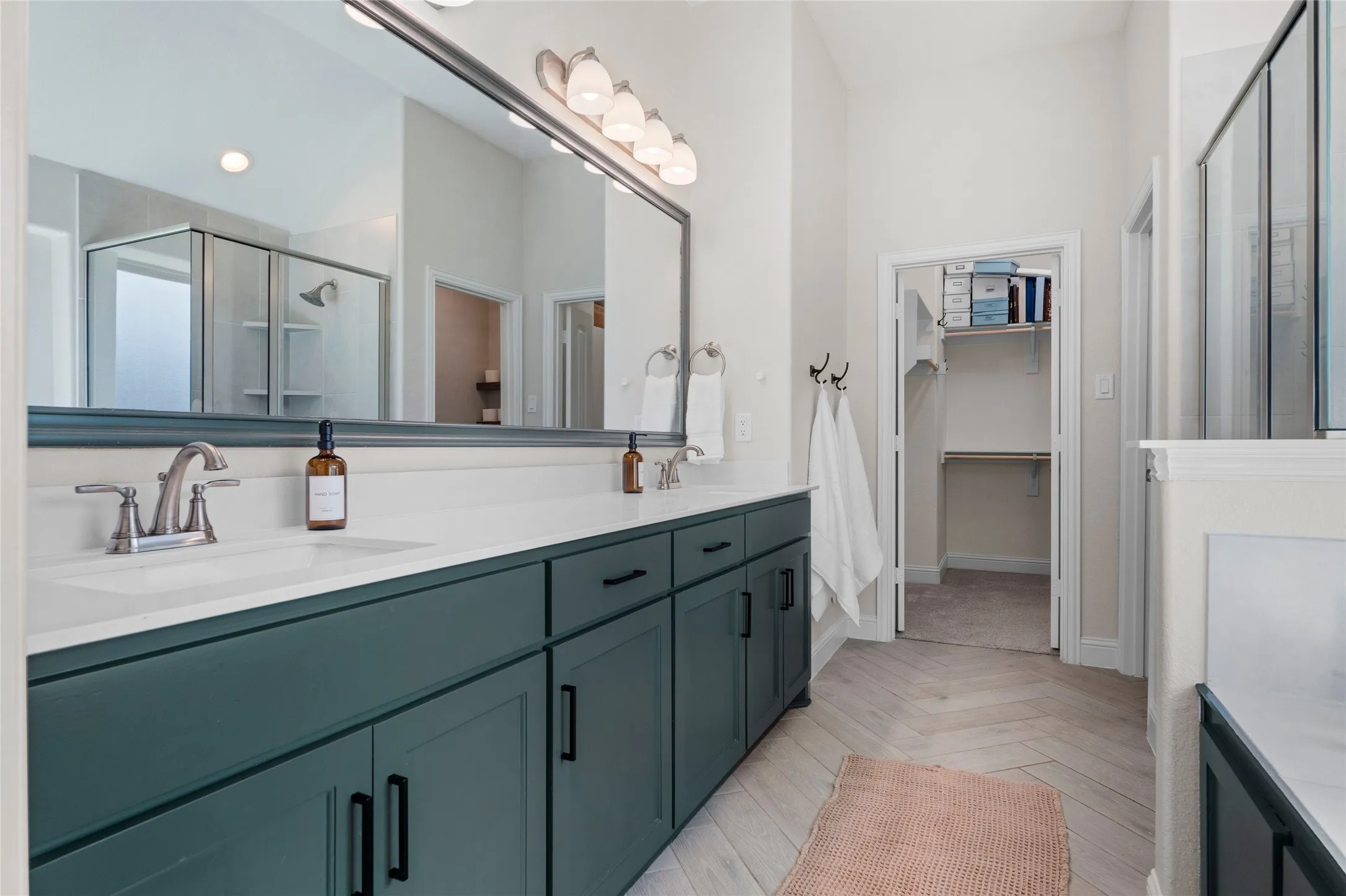 Dual vanity with a white countertop and dark green cabinetry