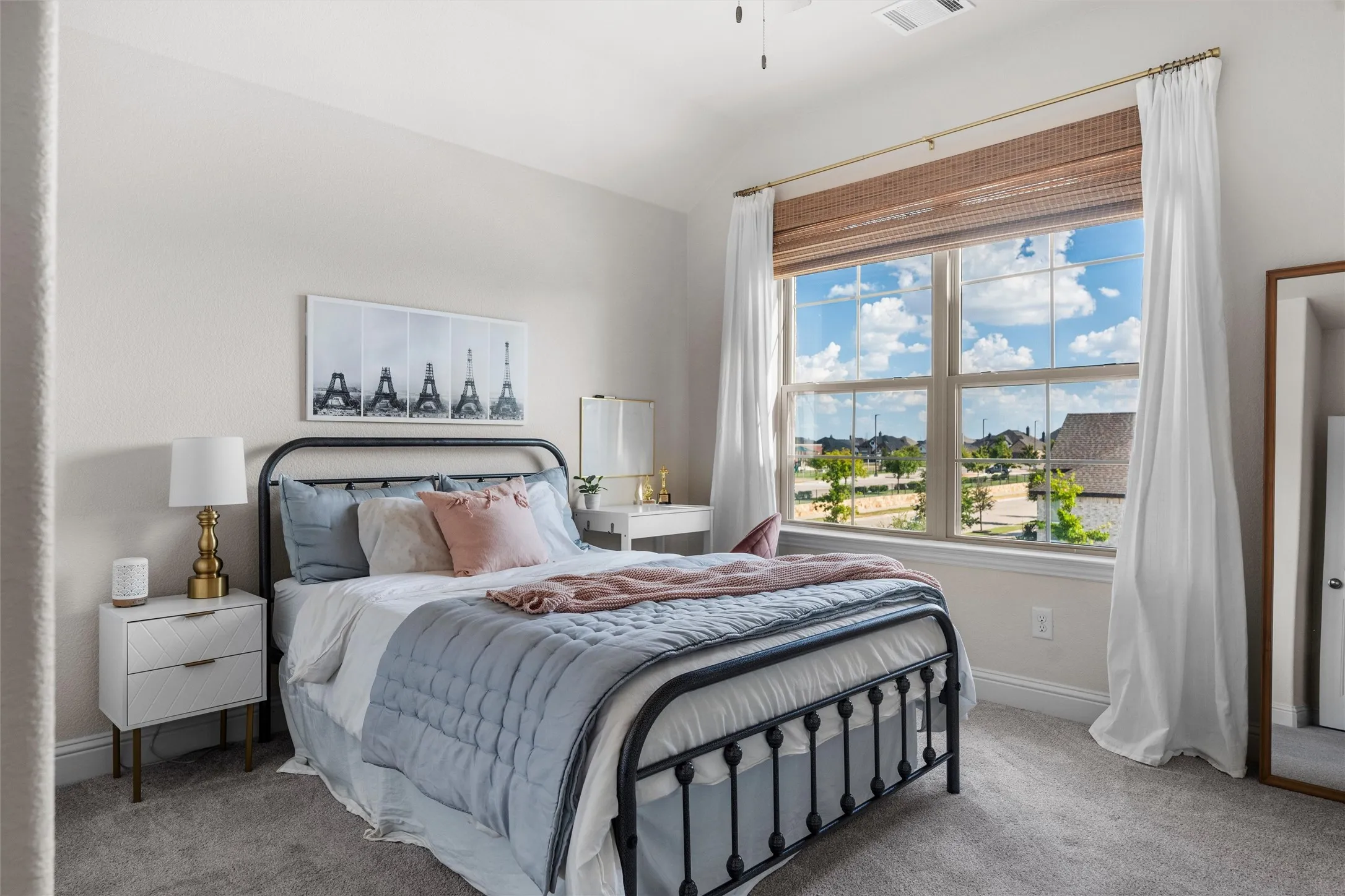Spacious room featuring a large window with natural fiber blinds, neutral wall paint, and plush carpet flooring