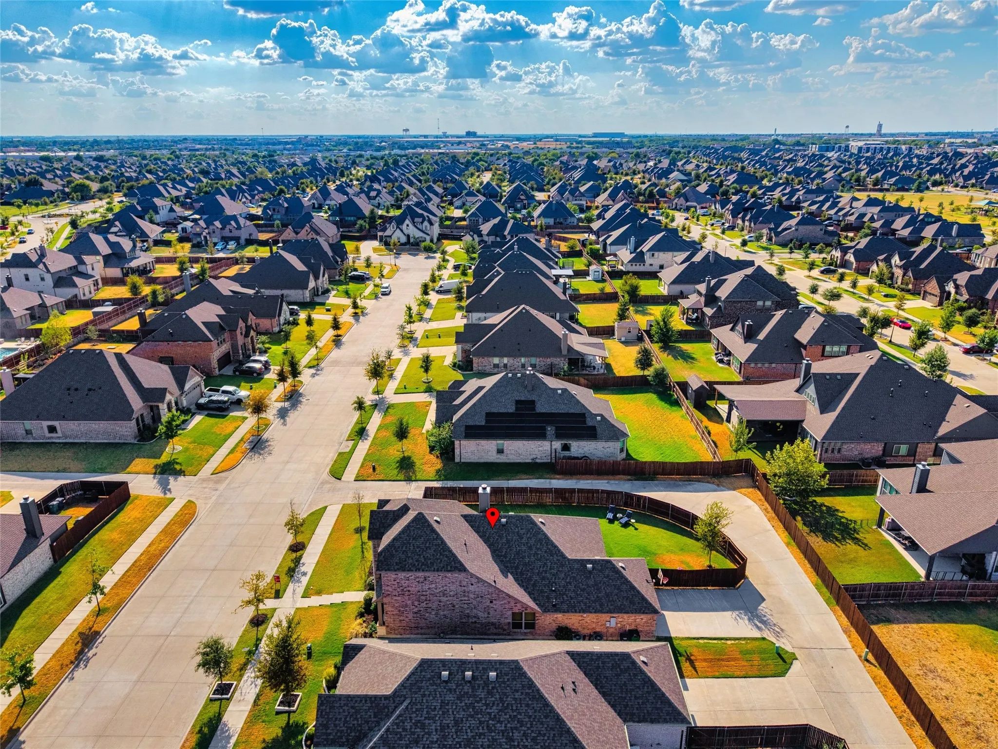 Residential neighborhood featuring numerous single-family homes with dark-pitched roofs and brick exteriors