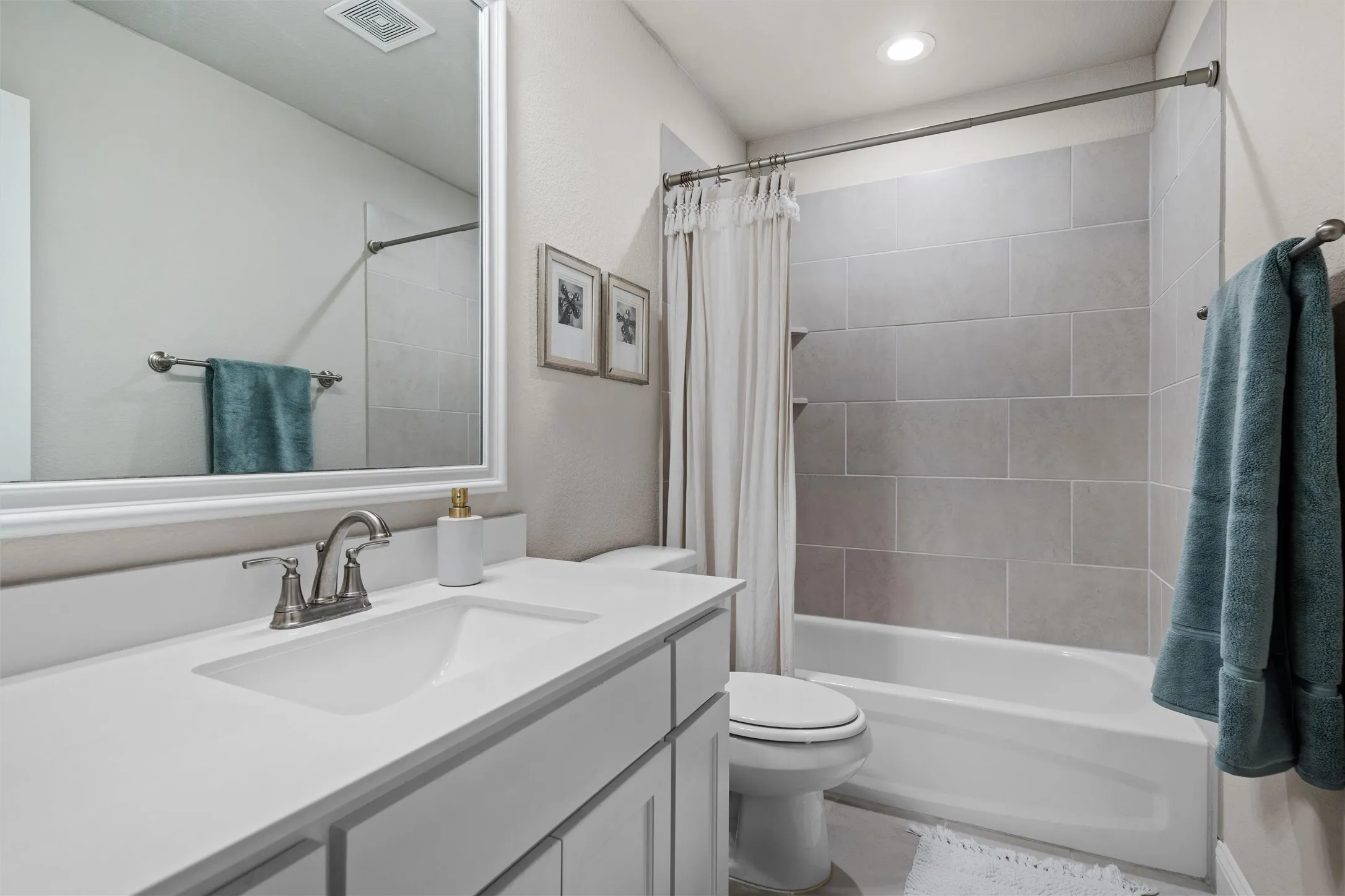 Vanity with integrated sink, brushed nickel faucet, and framed mirror
