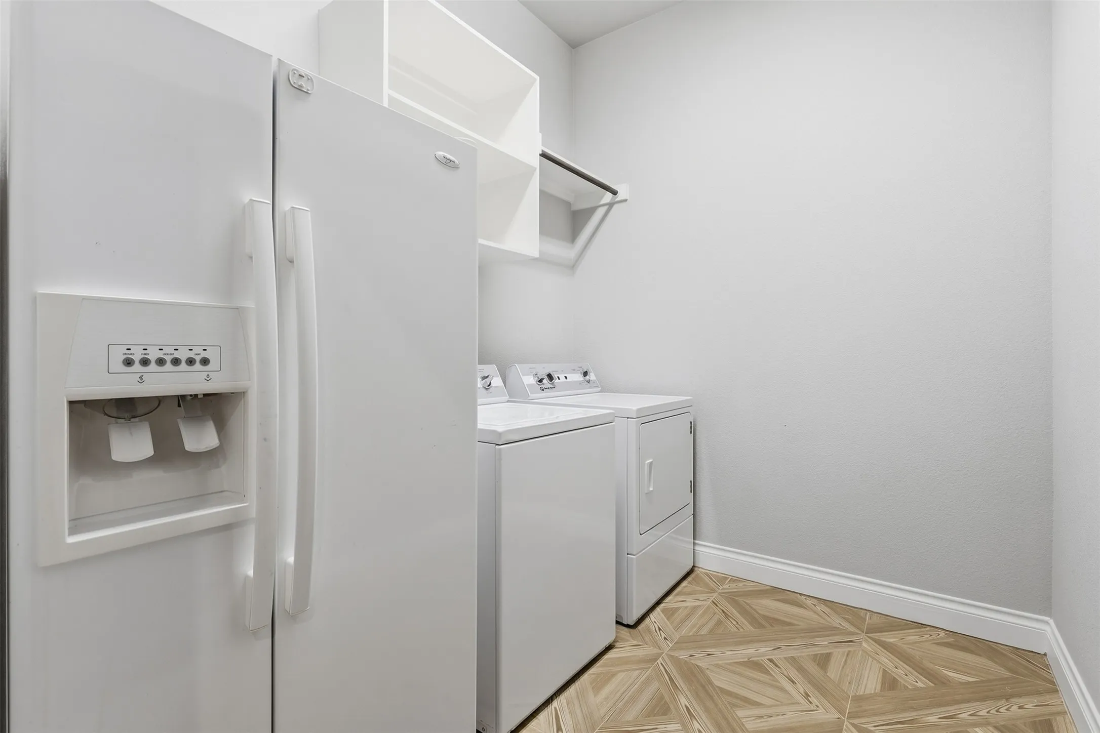 Recessed shelving, built-in rod, wood-finish flooring, and white baseboards