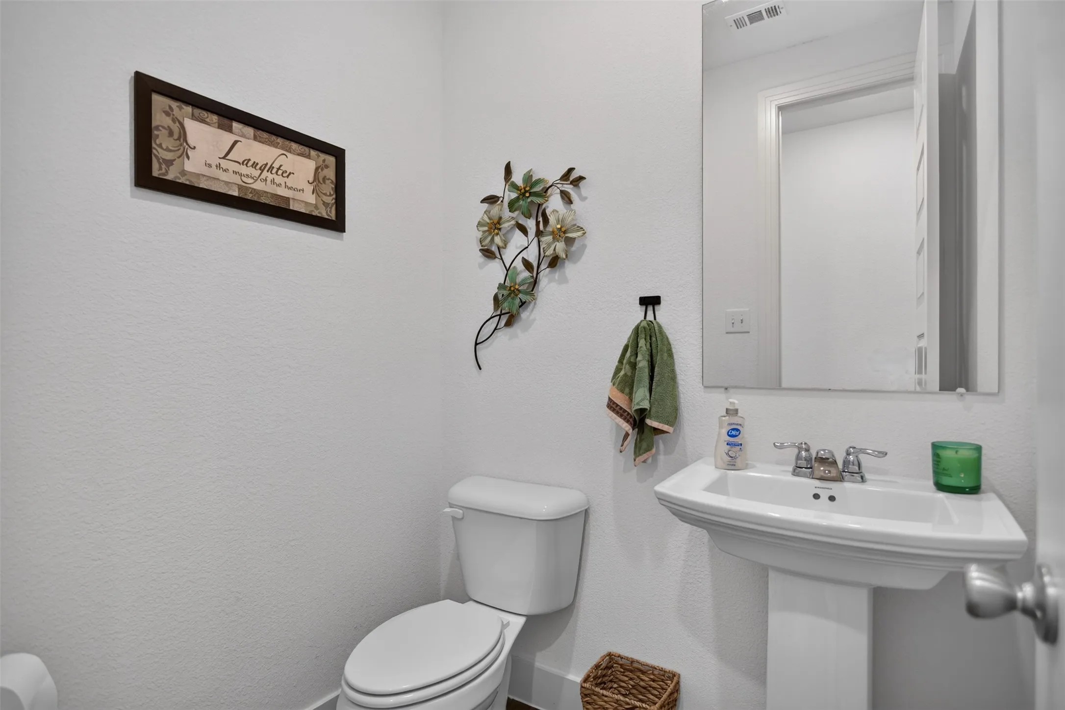 Pedestal sink with chrome fixtures and a rectangular mirror