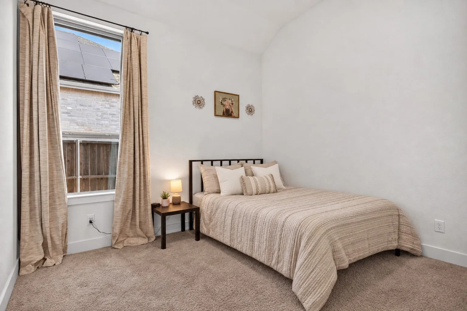 Bright room with a large window and neutral-toned carpeting