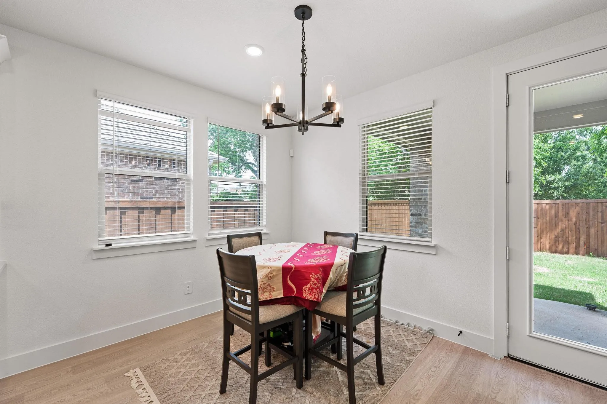 Wood-finish flooring, recessed lighting, and a modern chandelier