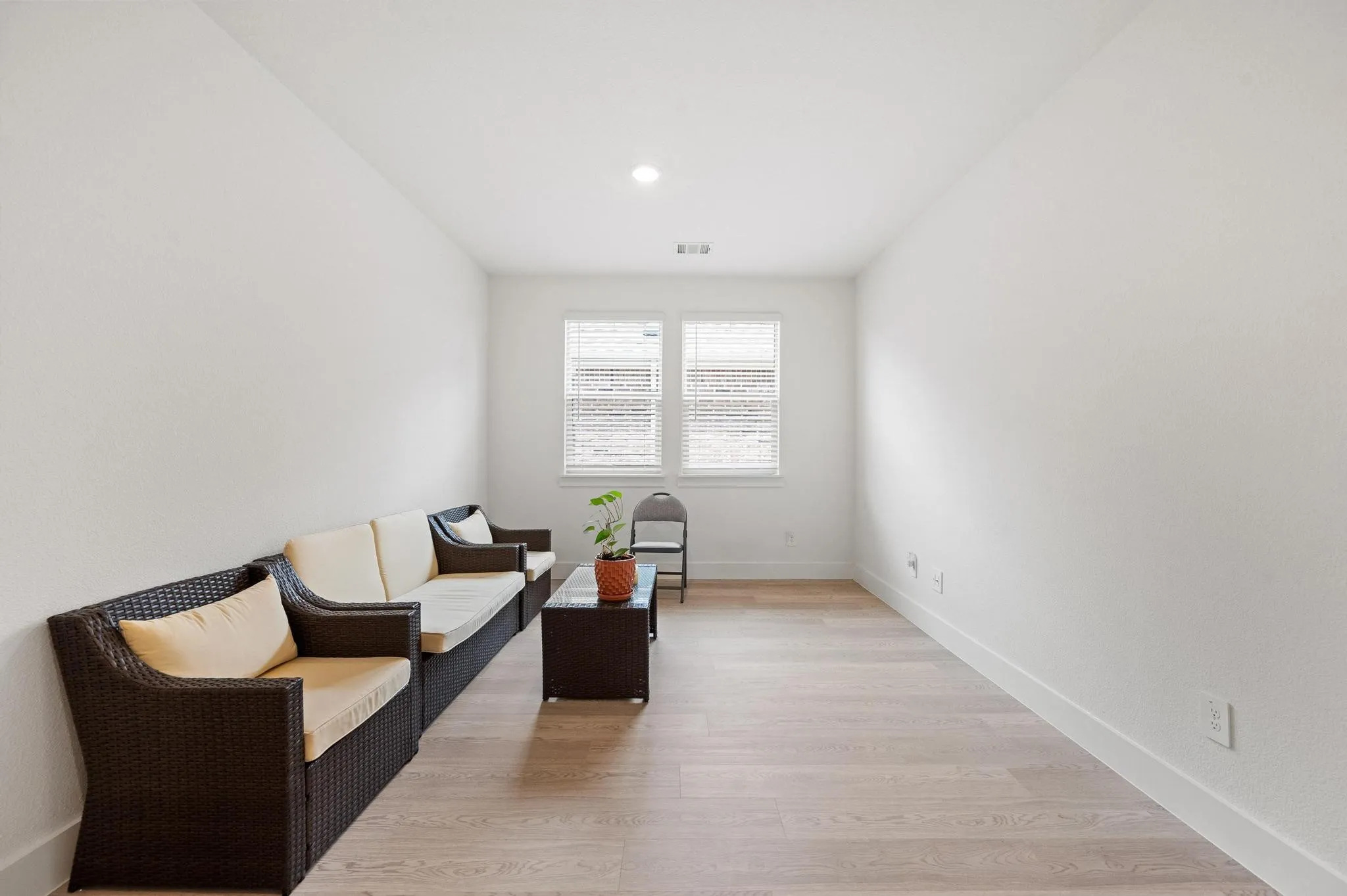 Recessed ceiling lighting, light wood-finish flooring, and white walls