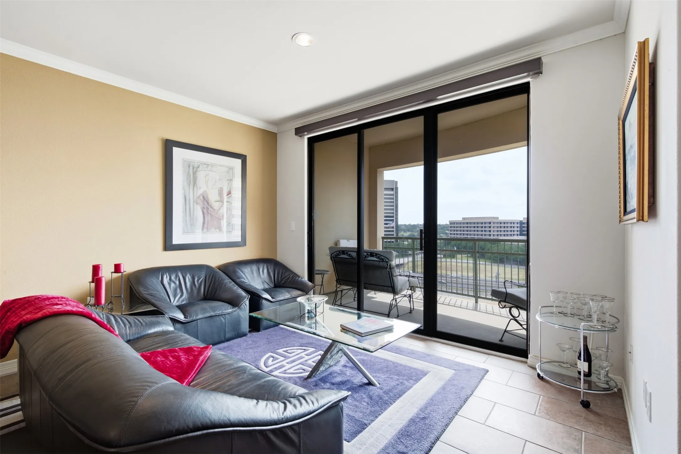 Sliding glass doors opening to a private balcony, recessed ceiling lighting, crown molding, and tiled flooring