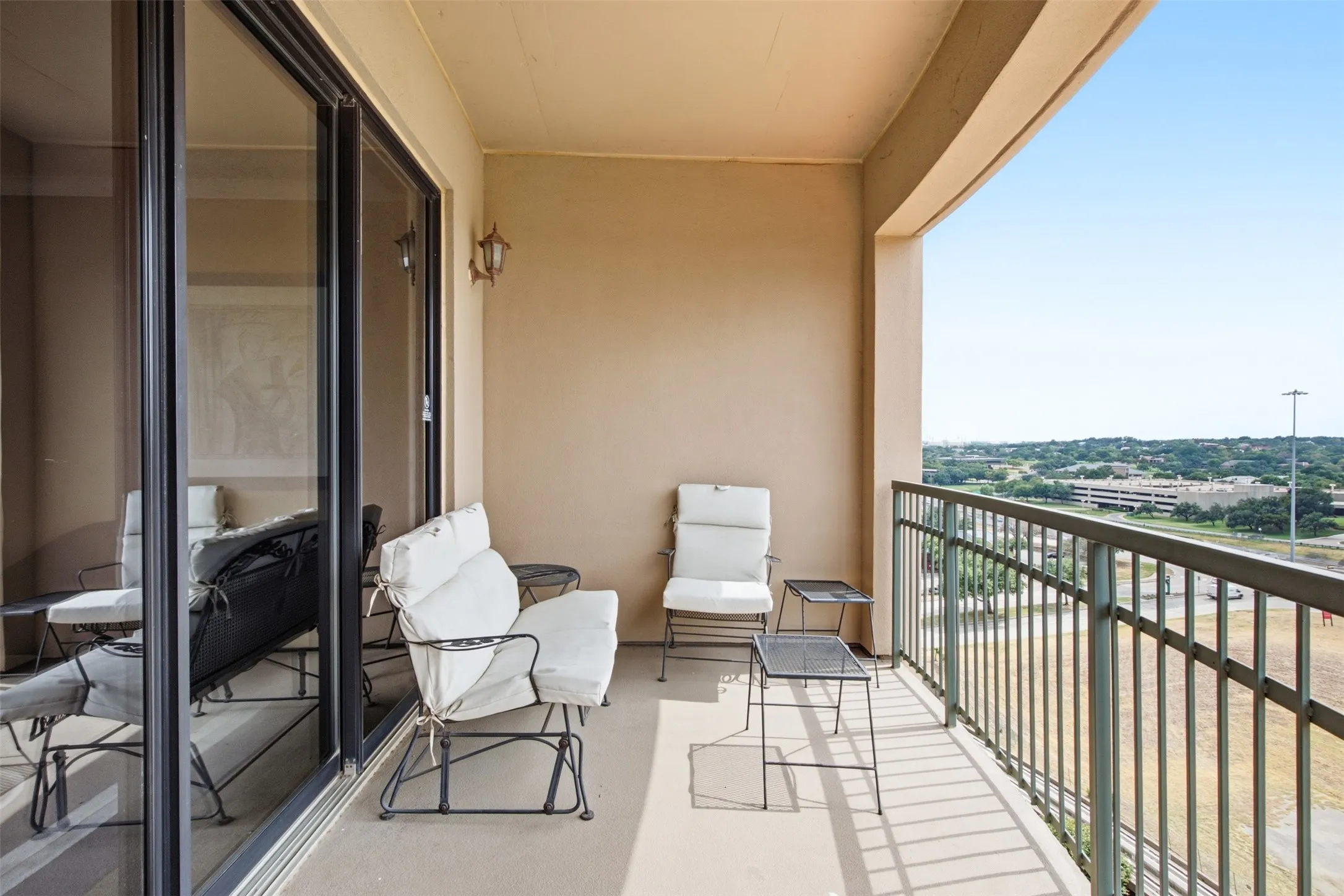 Private balcony featuring a metal railing and a high-level open-air perspective