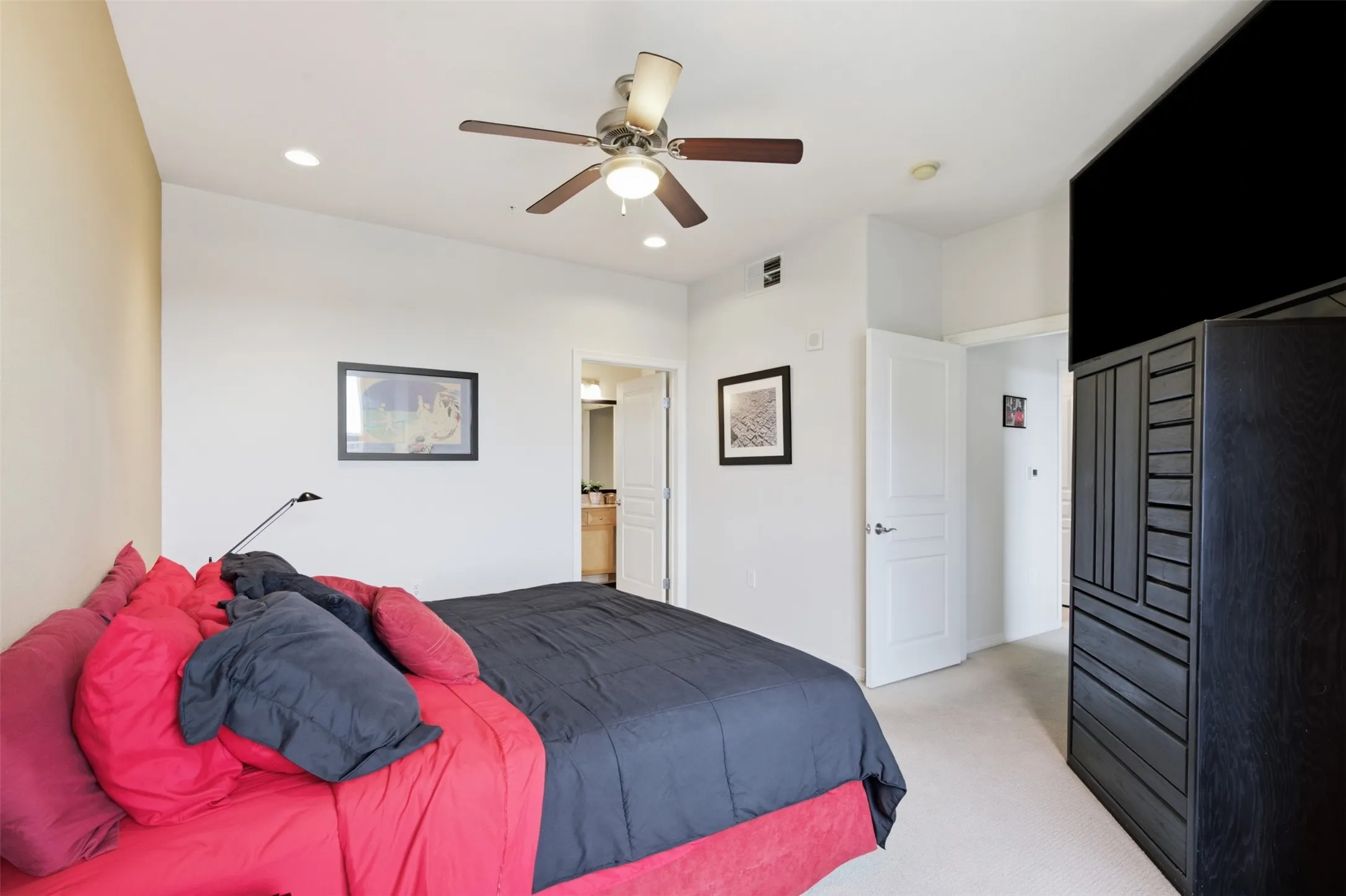 Recessed lighting, ceiling fan with integrated light, and light-colored carpet flooring