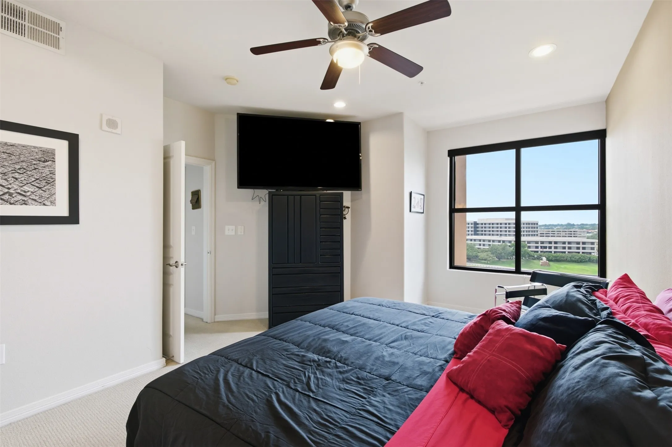 Carpeted flooring, ceiling fan with integrated lighting, recessed lighting, and a large window with black framing