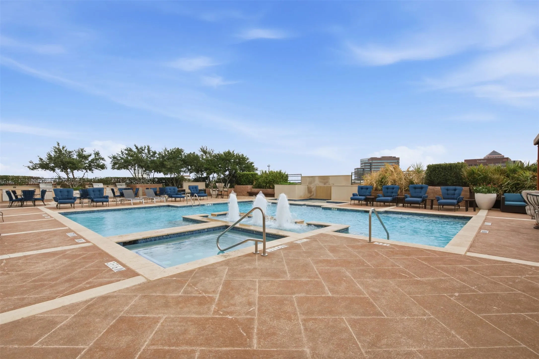 Expansive outdoor pool area featuring a multi-level swimming pool with water features, a hot tub, and surrounding lounge seating