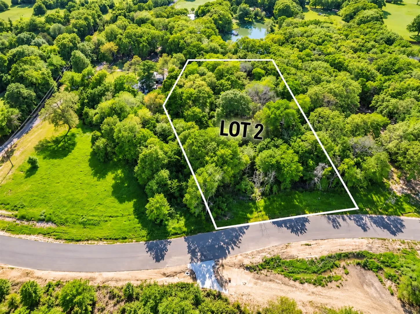 Expansive lot with mature trees and a paved road frontage