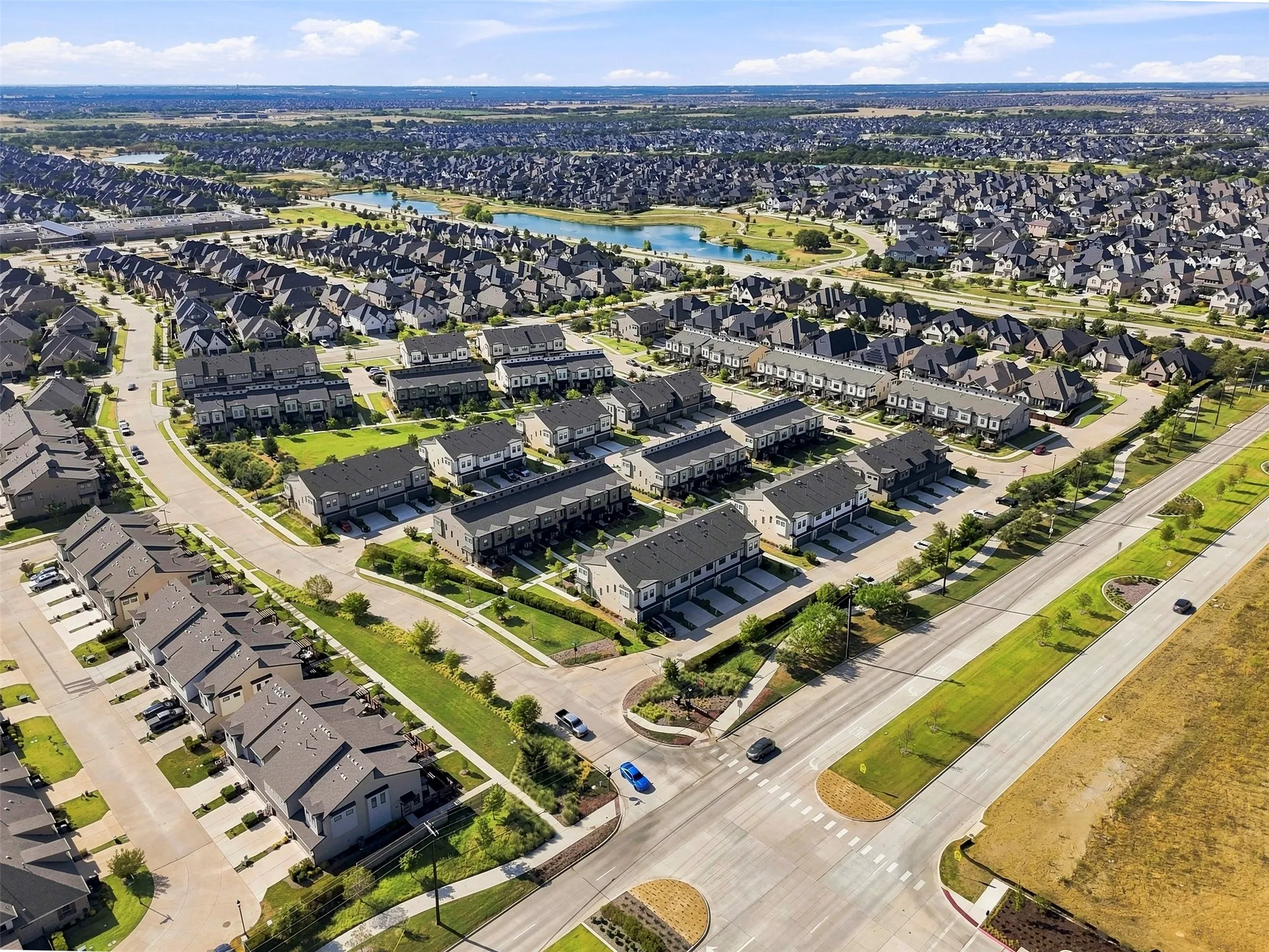 Aerial perspective of a developed residential community with townhomes and detached properties