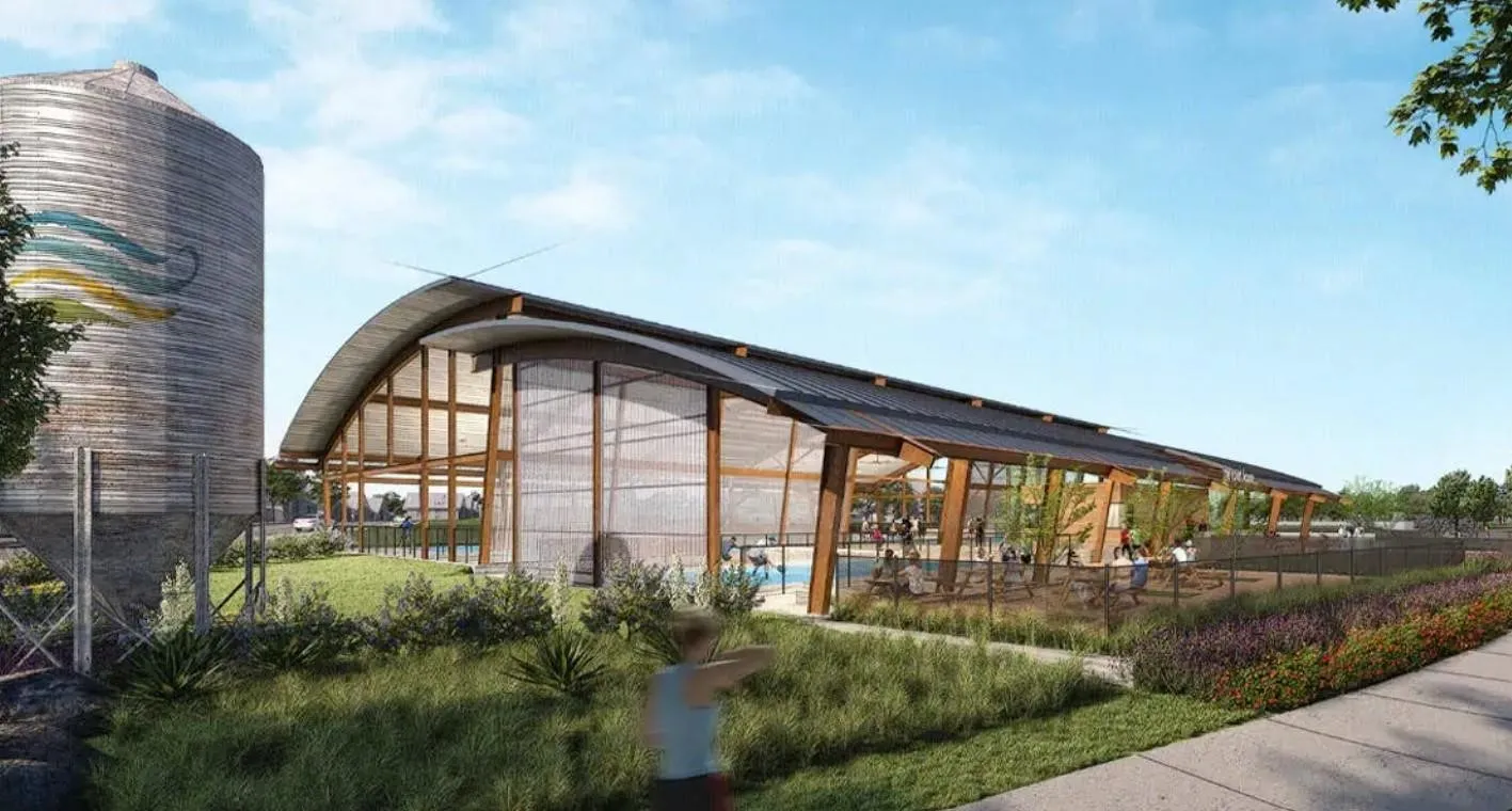 Curved roof structure with extensive glazing, exposed timber framing, and an outdoor pool area