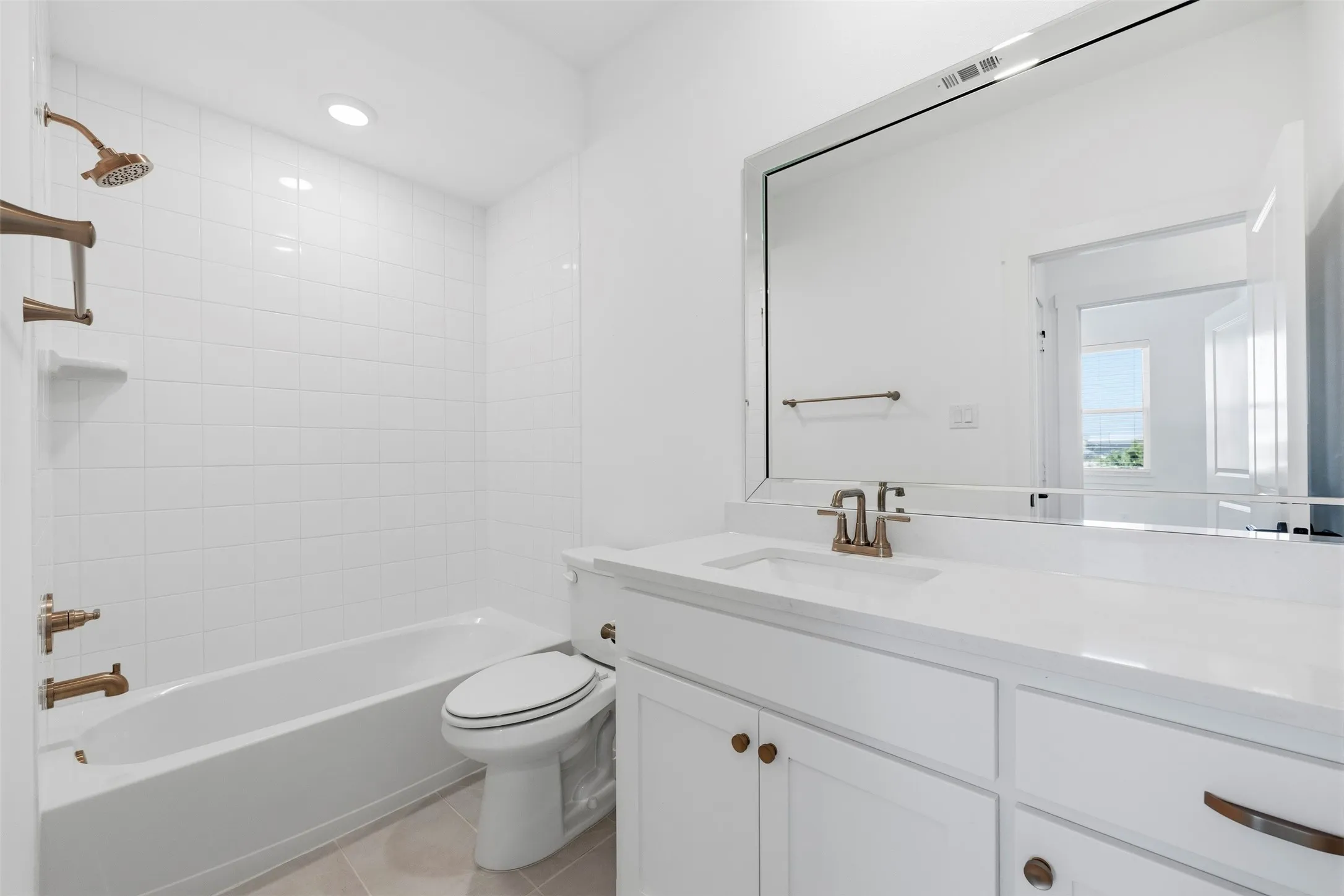 White tile surround shower-tub combination with bronze fixtures