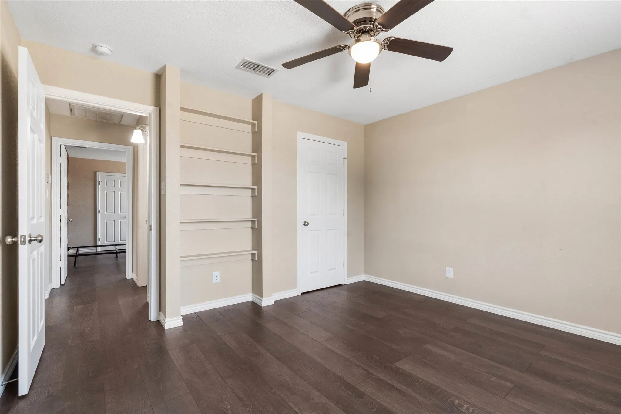 Unfurnished bedroom with ceiling fan, dark hardwood / wood-style flooring, and a closet